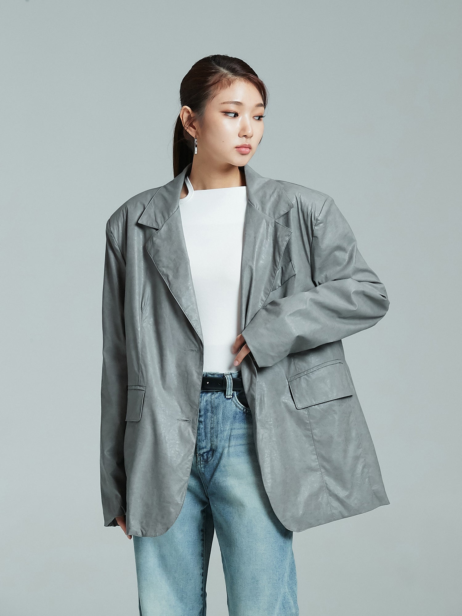 Side look of the model wearing the leather jacket showcasing the chic korean street fashion look.