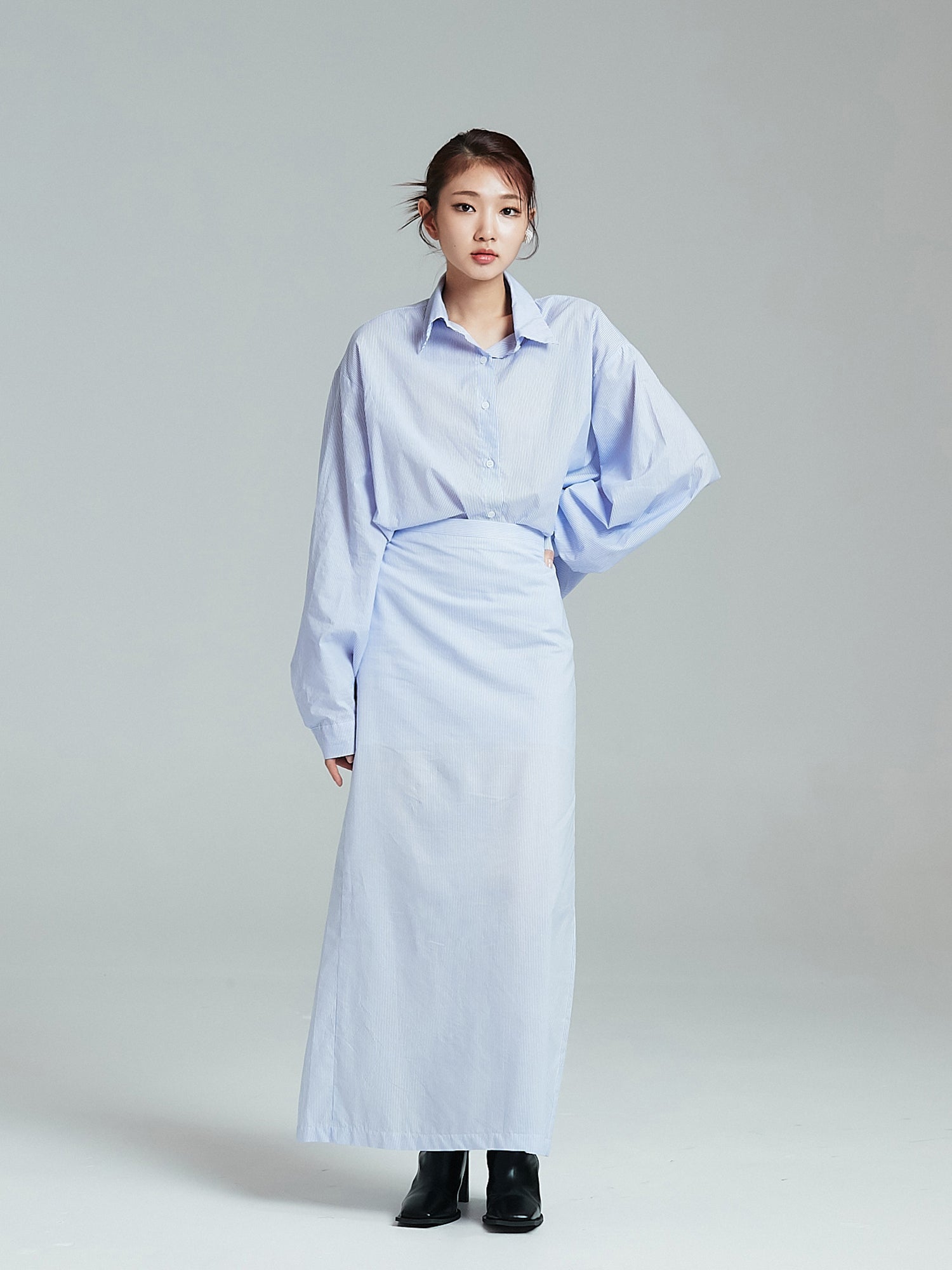 The model is standing while wearing the oversized shirt to showcase its south Korea fashion.