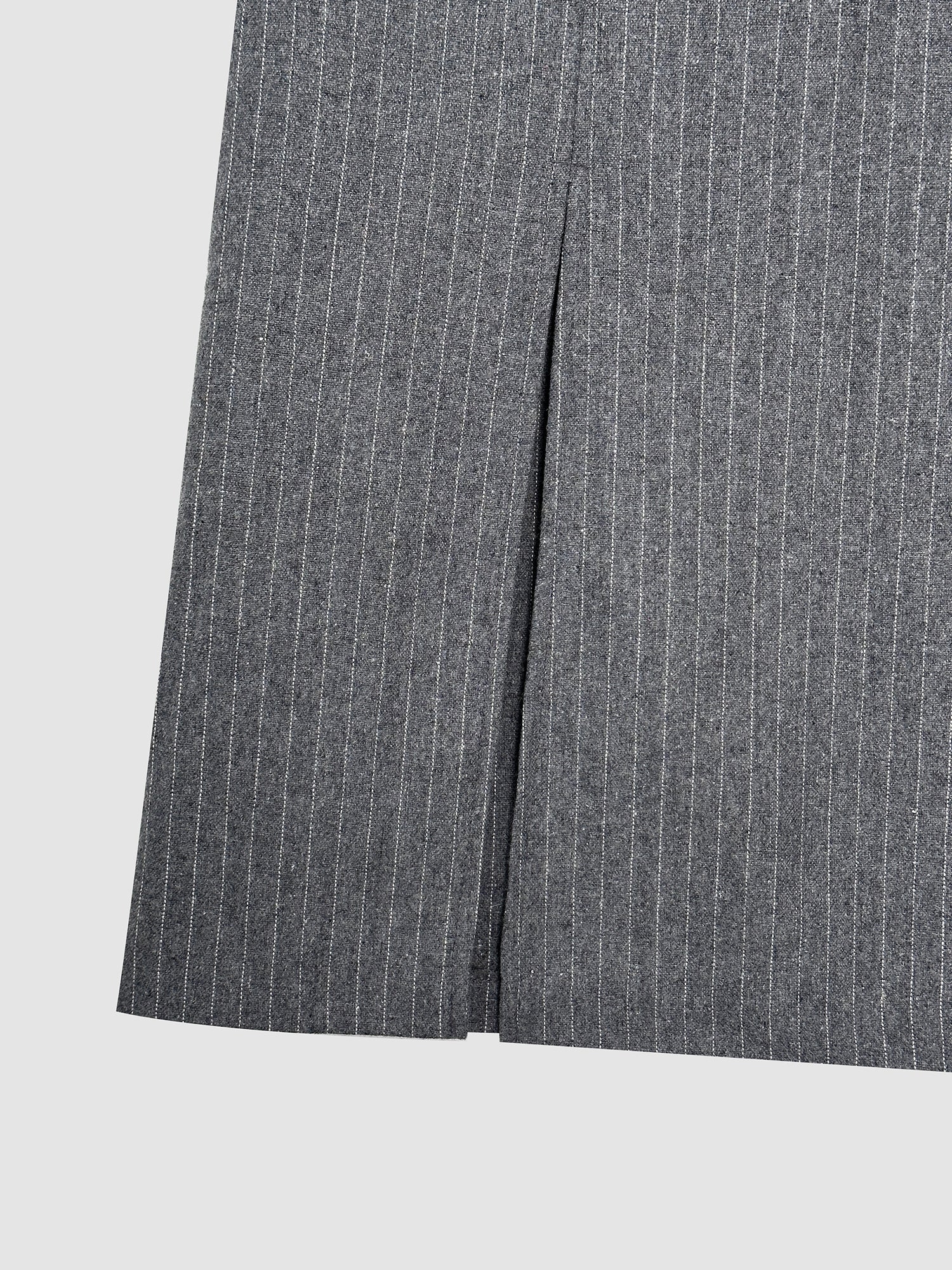 A close-up view of the pinstripe pleated skirt to showcase its pinstripe fabric pattern and its pleated design details.