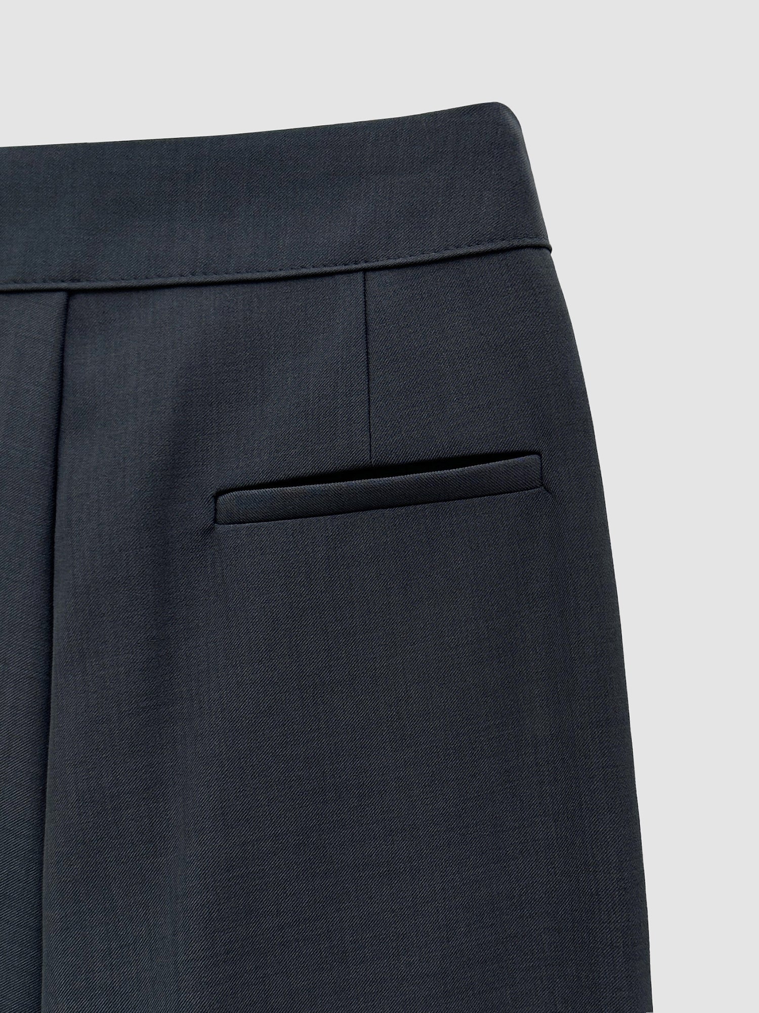 A zoomed-in detail view of the pintuck wide leg trouser showcasing the back pocket detail and seam stitching of the trouser.