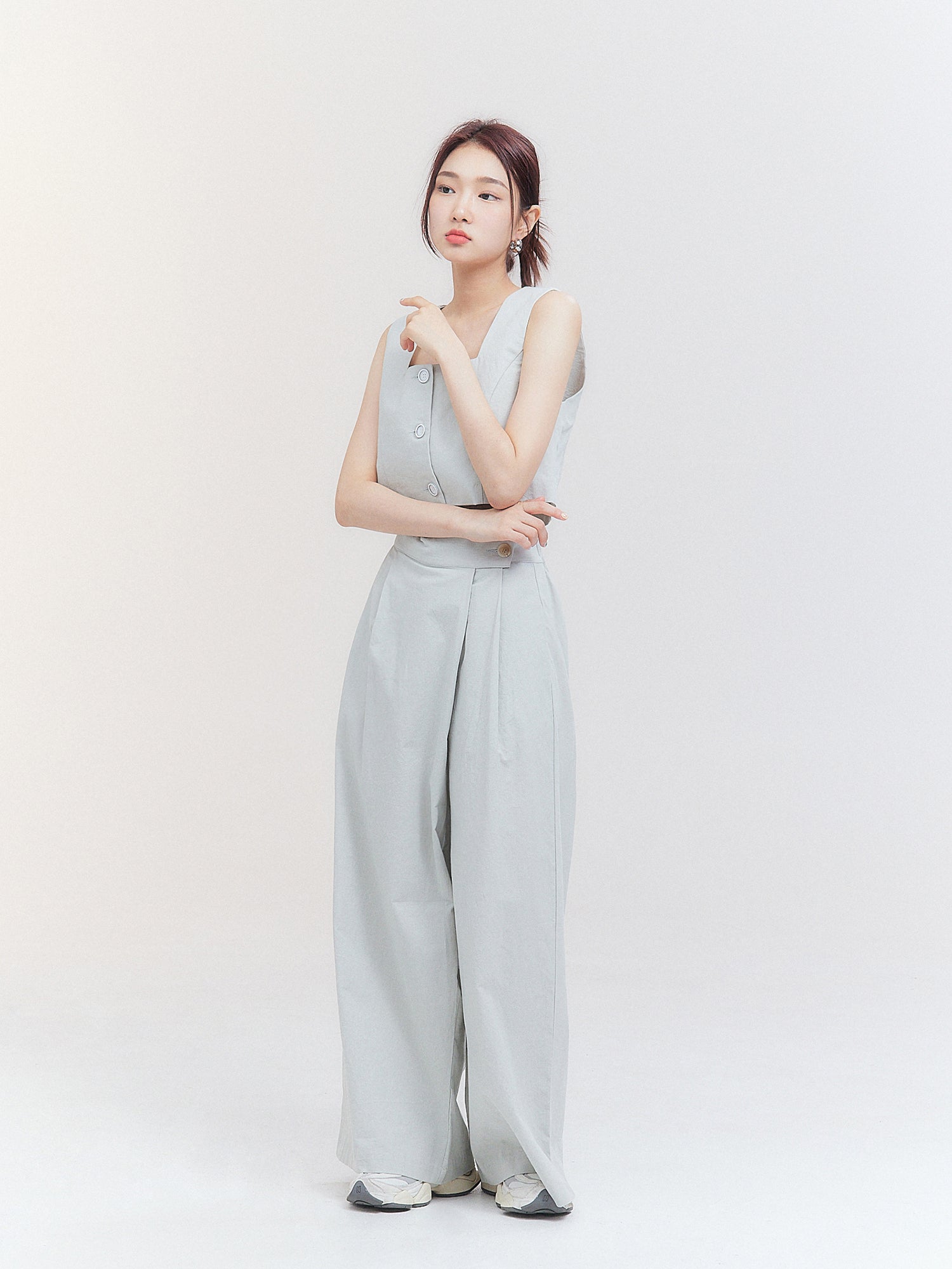 A front view of the model wearing the pleated slit skirt pants, exemplifying contemporary fashion with its modern and stylish design.