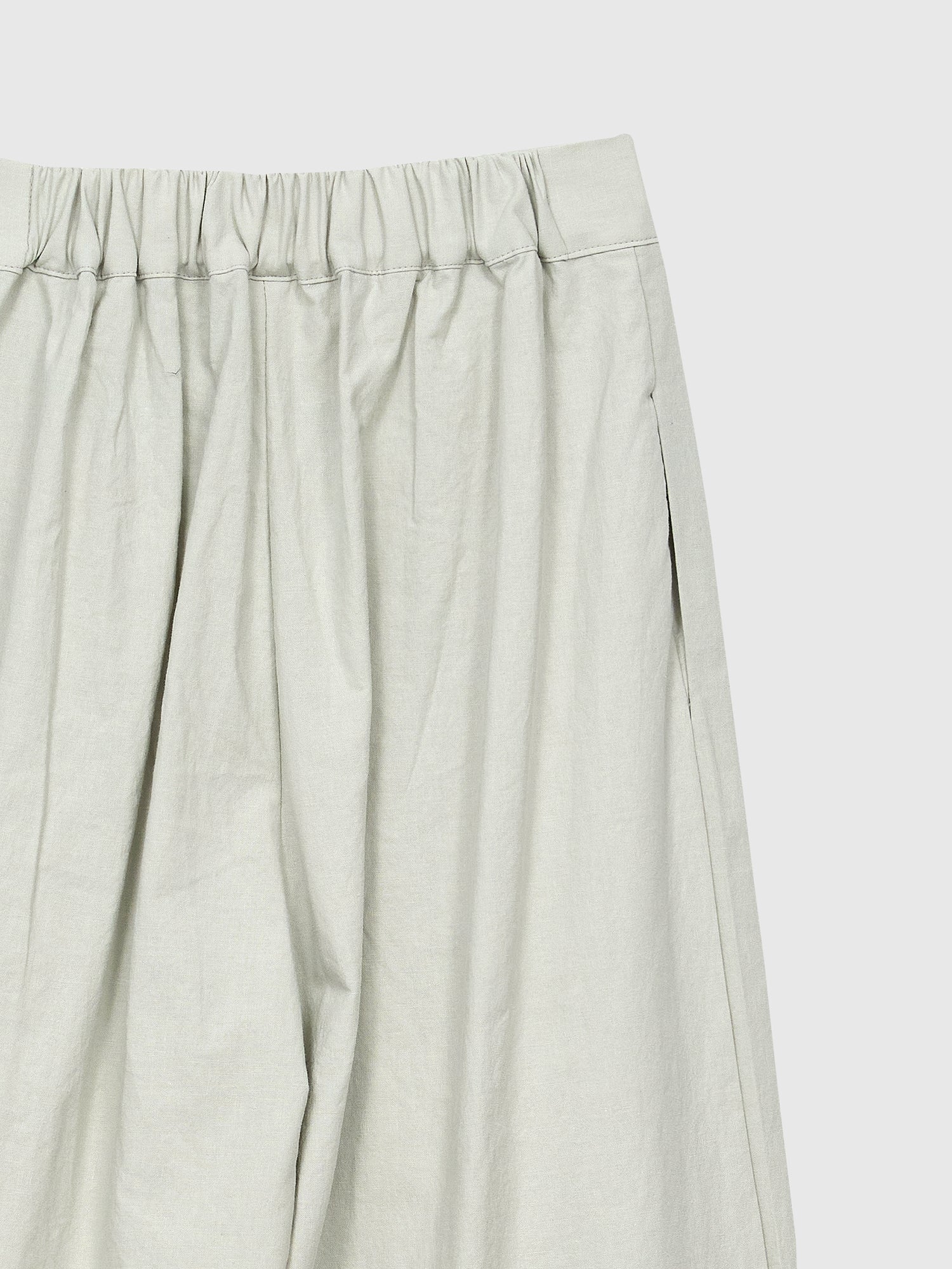 Close-up view of the Pleated Slit-cut Midi Skirt showing the elastic waist band detail on the back.