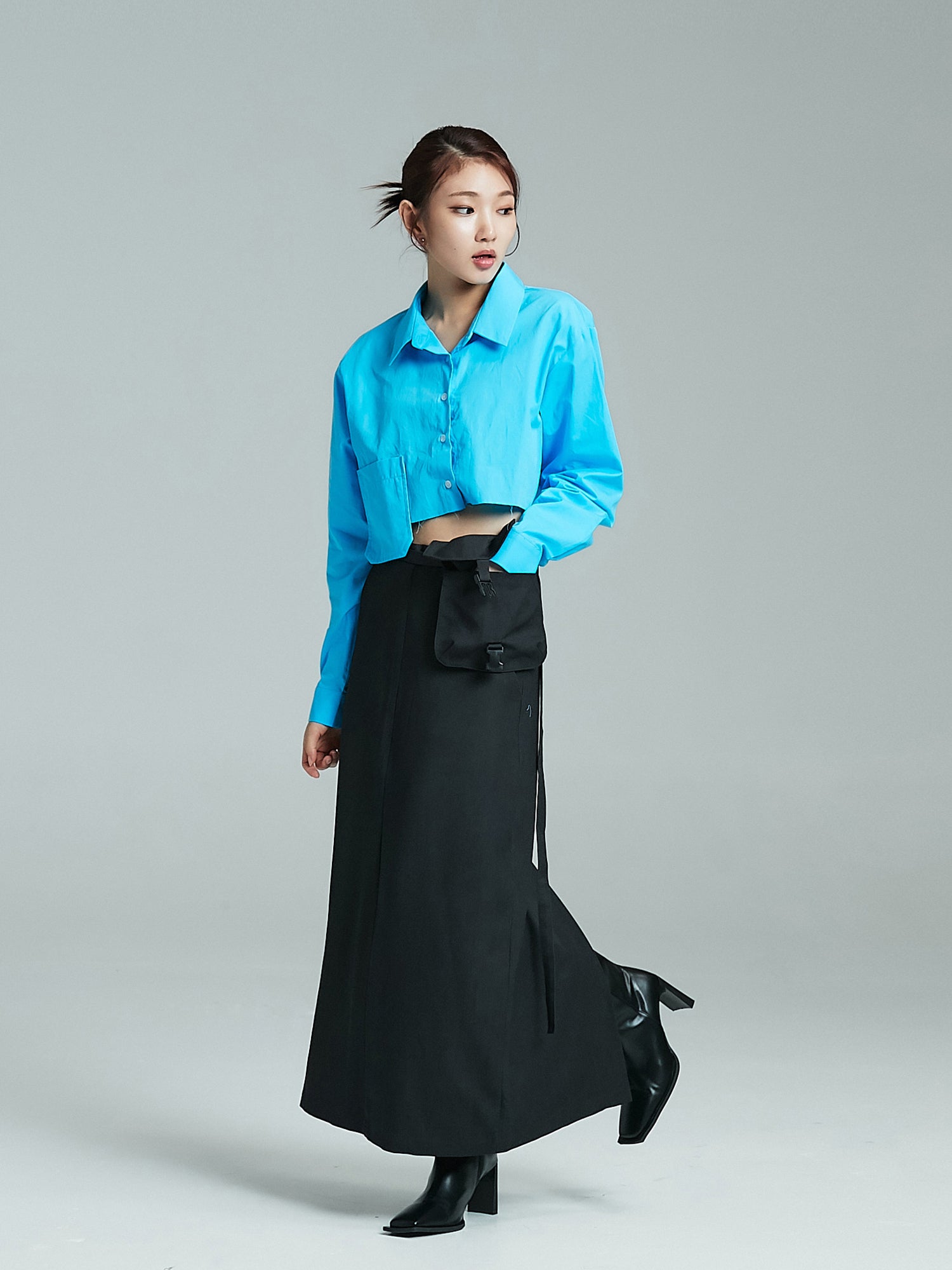 A tilted angle of the model wearing the blue pocket cropped shirt matching it with the pocket maxi skirt. 