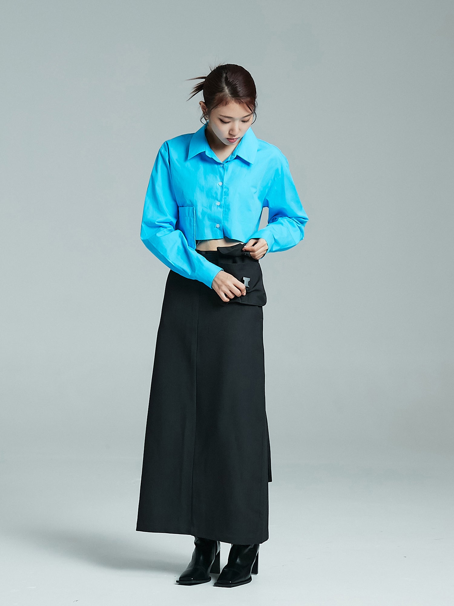 The front view of the model in a pocket maxi skirt as she elegantly opens one of the pockets.