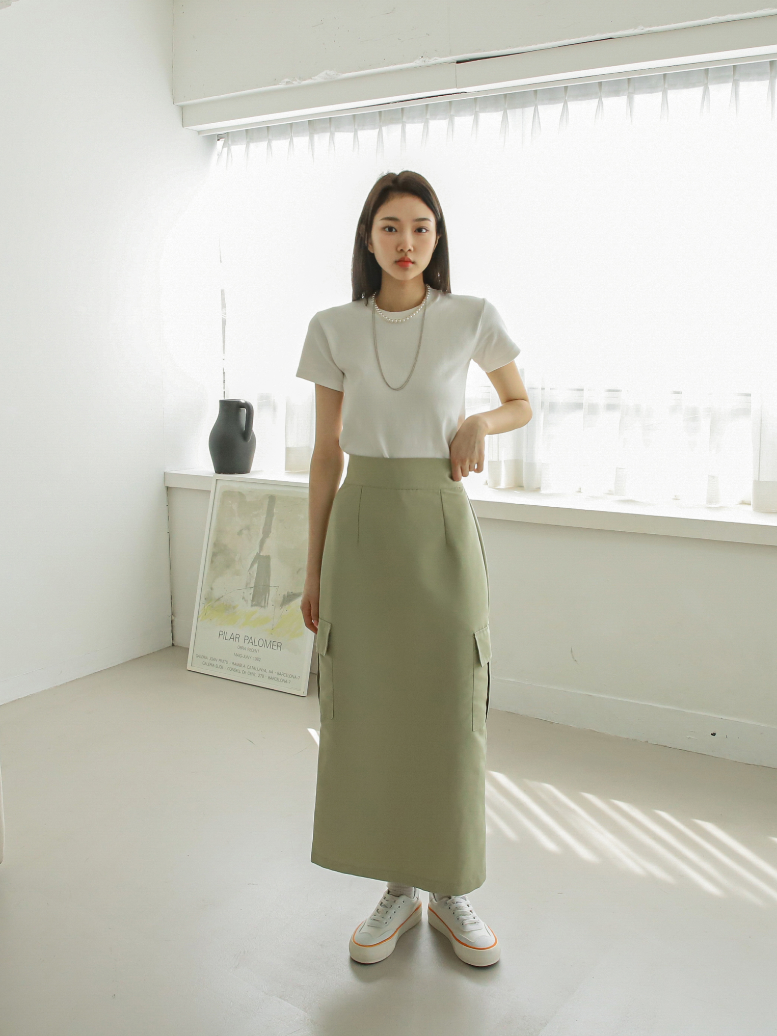 A front shot of the model wearing the pocket skirt, showcasing the midi length and the skirt's flattering fit on the model.