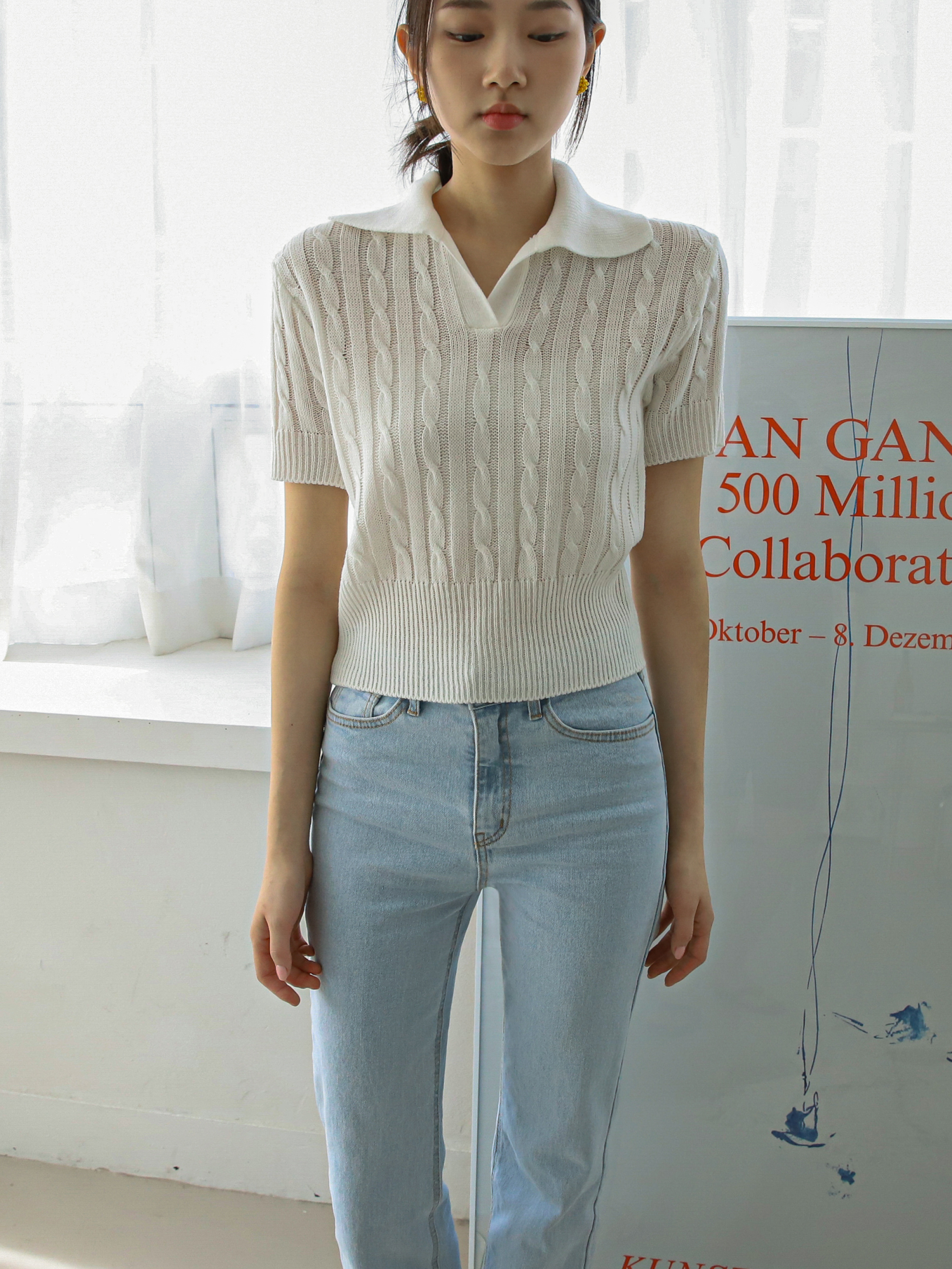 A front shot of the model wearing the ivory polo knit shirt, showcasing its South Korean fashion influence and stylish appeal.