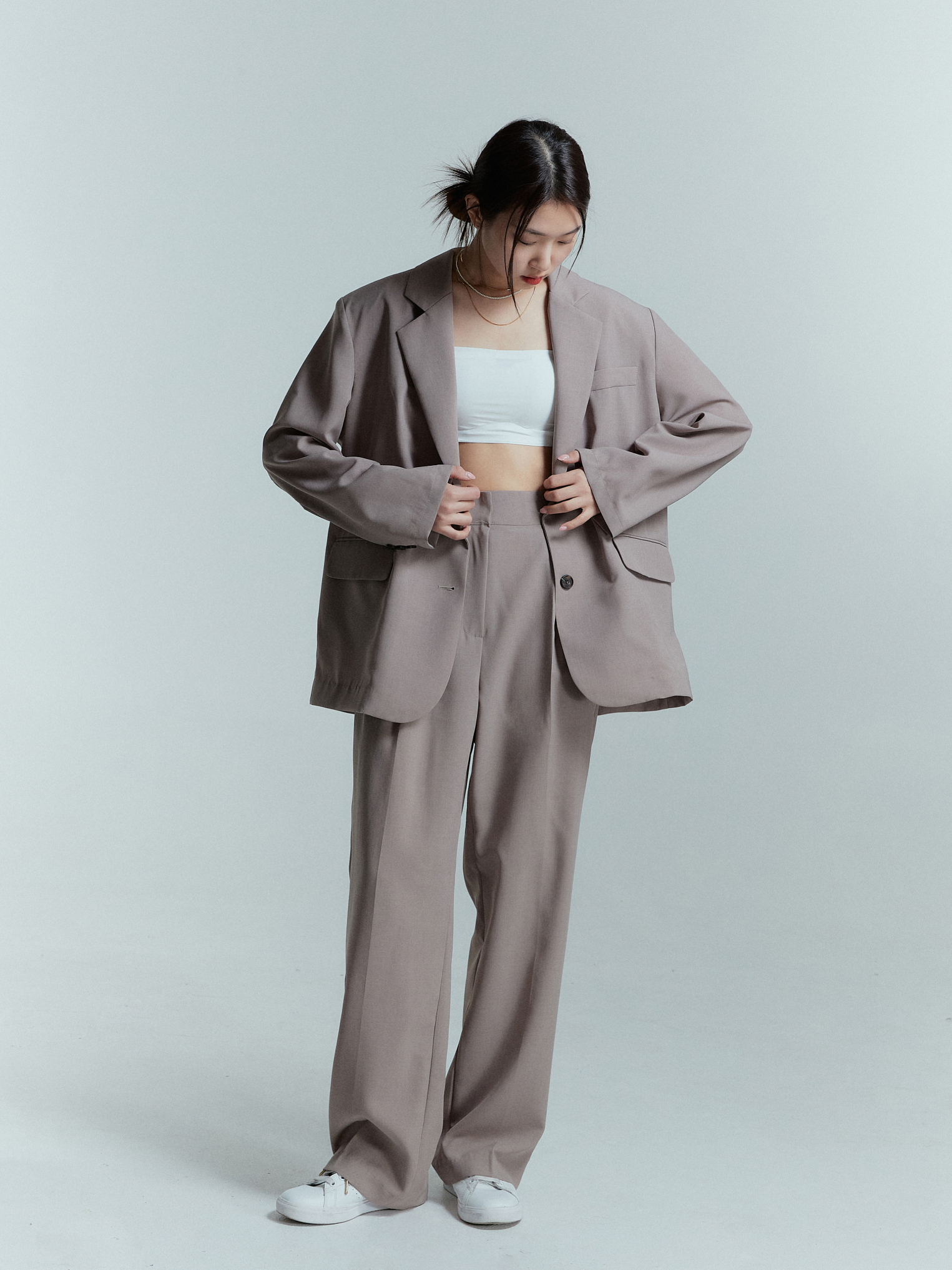 Full-shot of the model in Korean street fashion, confidently wearing the relaxed pleated trouser.