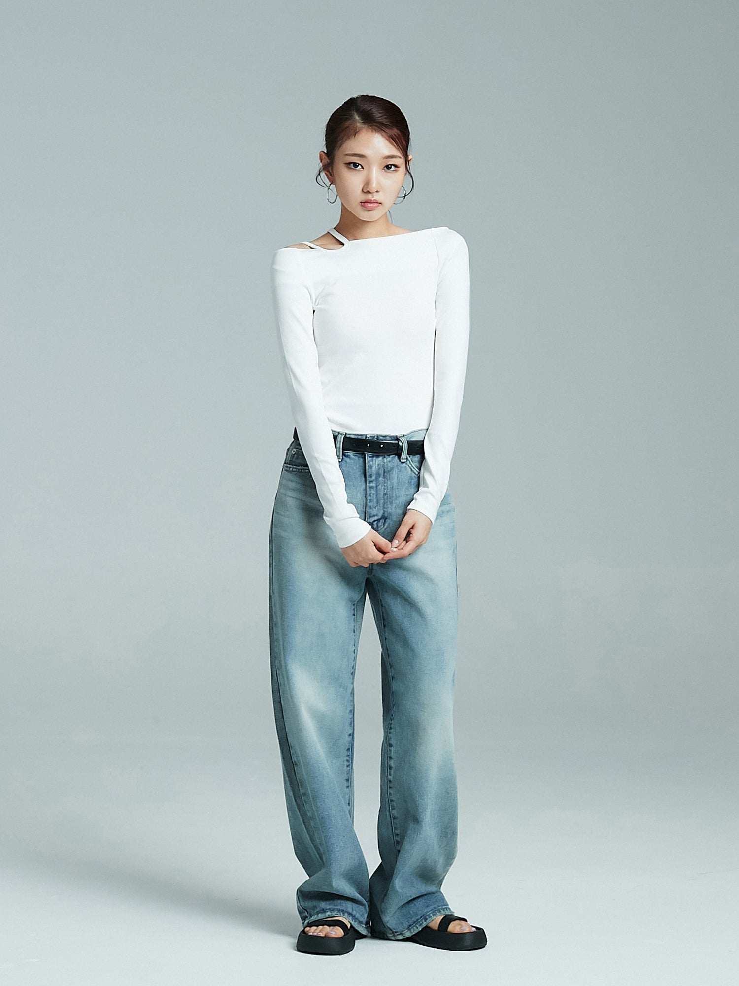 Capture a frontal perspective of the model effortlessly showcasing the relaxed wash jeans.