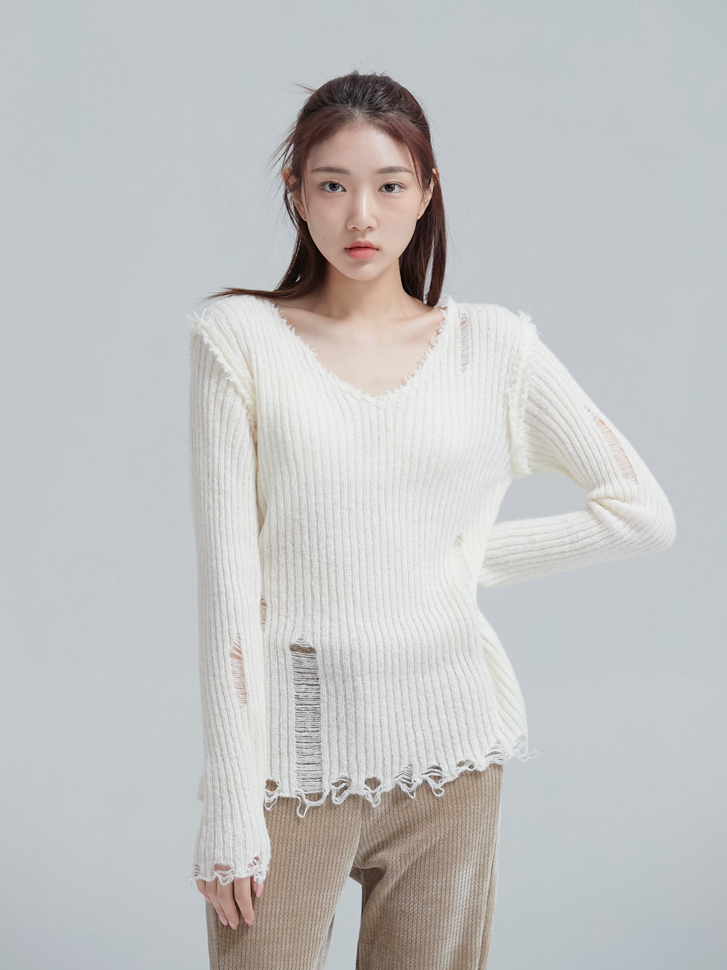 A close-up shot of the model wearing the ripped sweater to show its ripped texture detail.