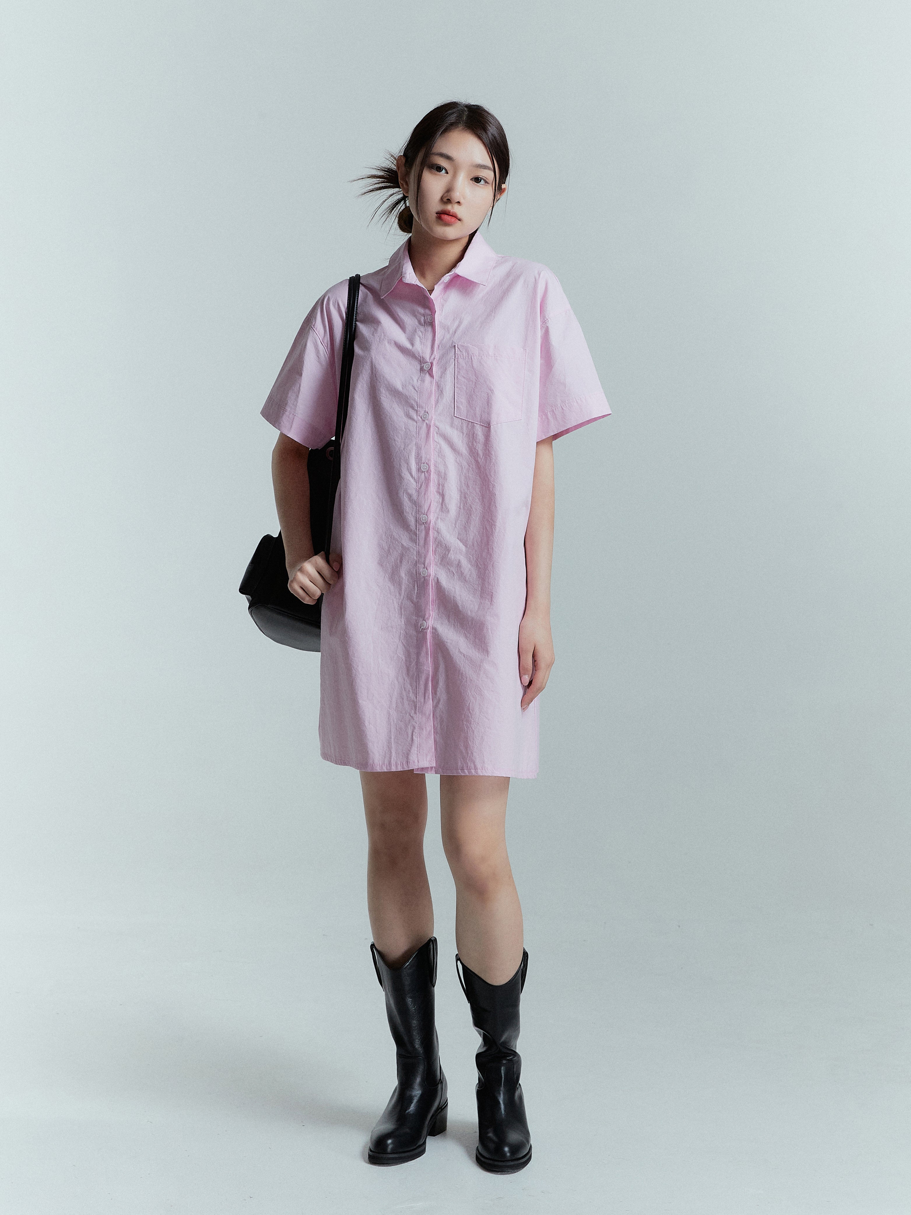 It's a capture of a model posing as she confidently wears the pink shirt dress.