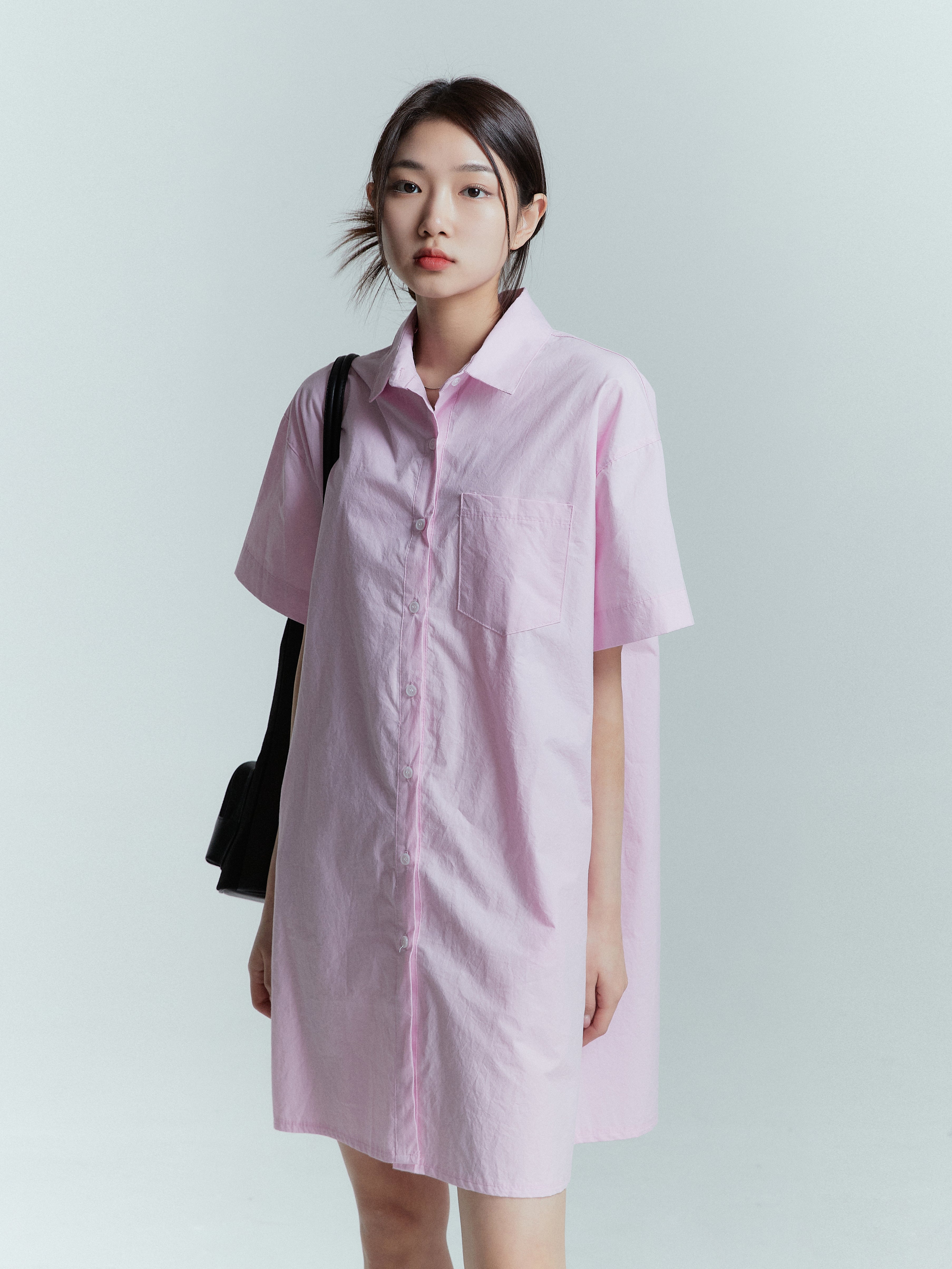 Slightly angled view of the model wearing the shirt dress showing the front side.