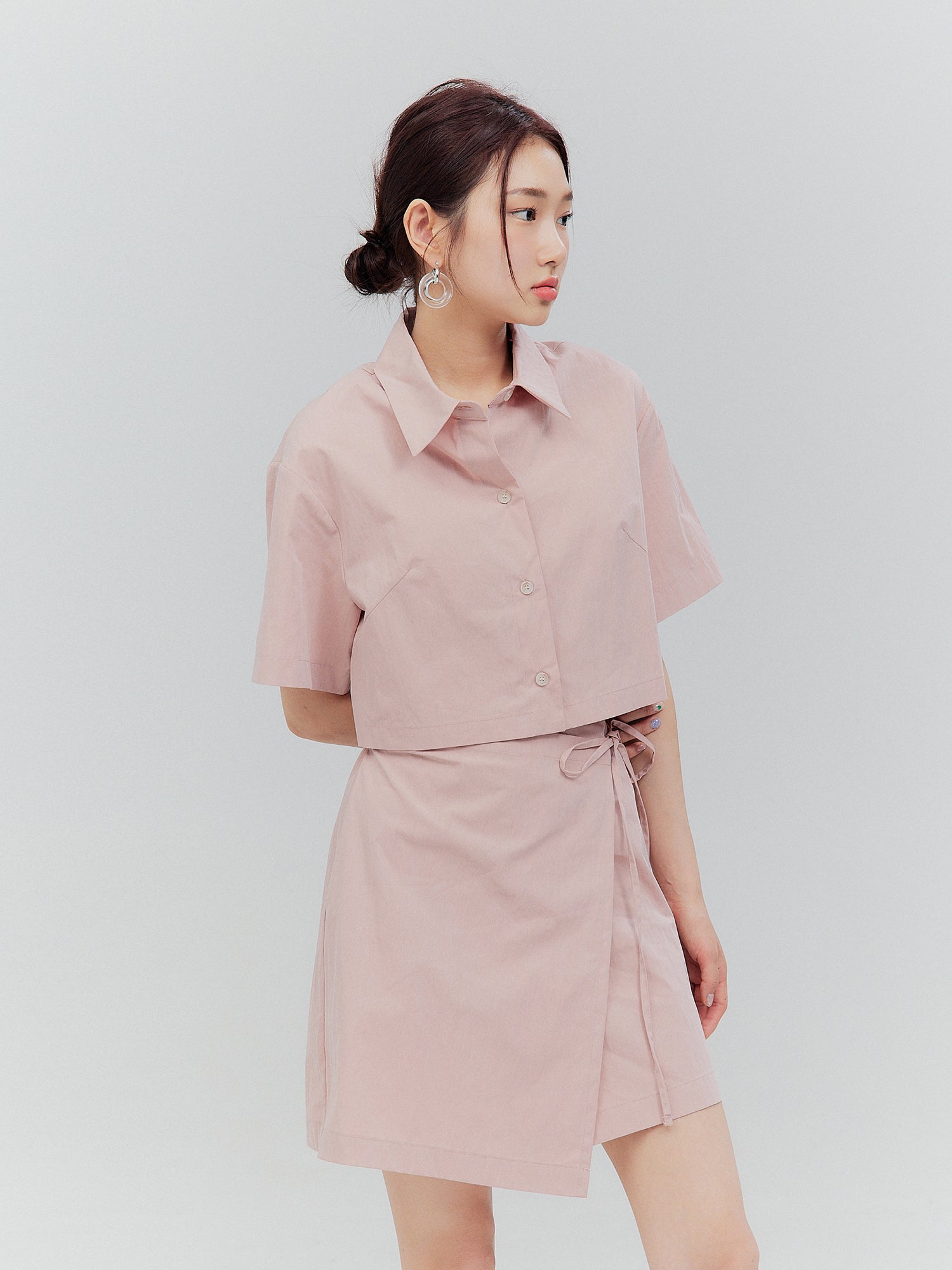 Capture the essence of Korean aesthetic outfits with a stylishly tilted view of the model donning the pink elasticated shirt dress.