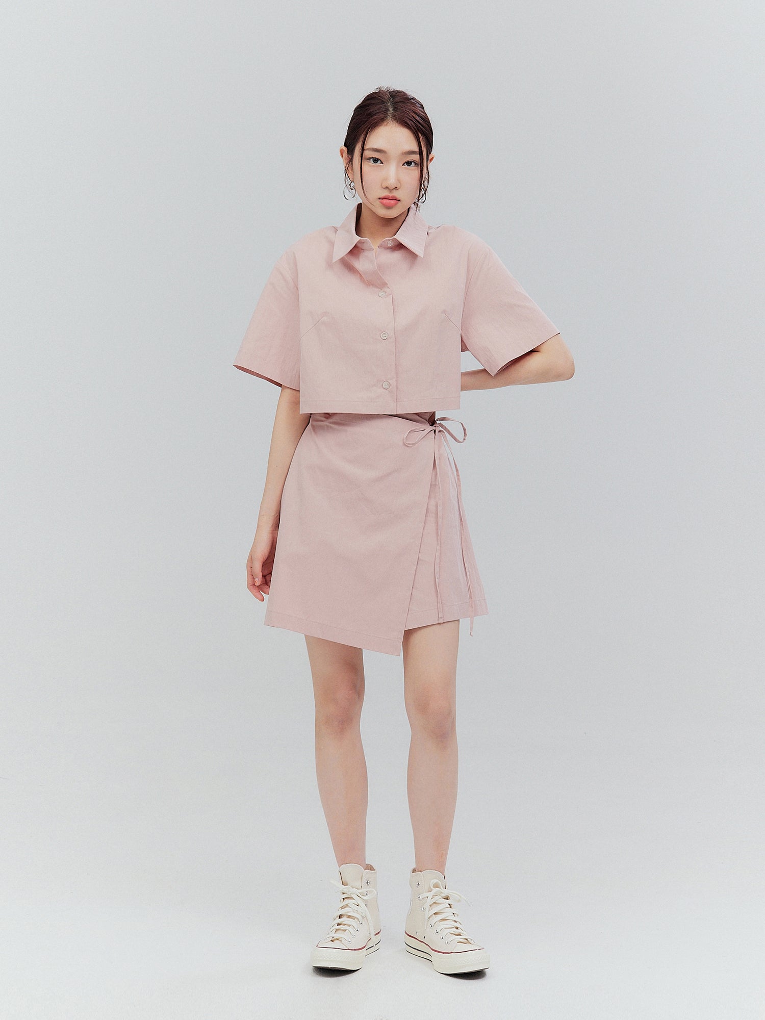 A full-shot of the model wearing the pink elasticated shirt dress.