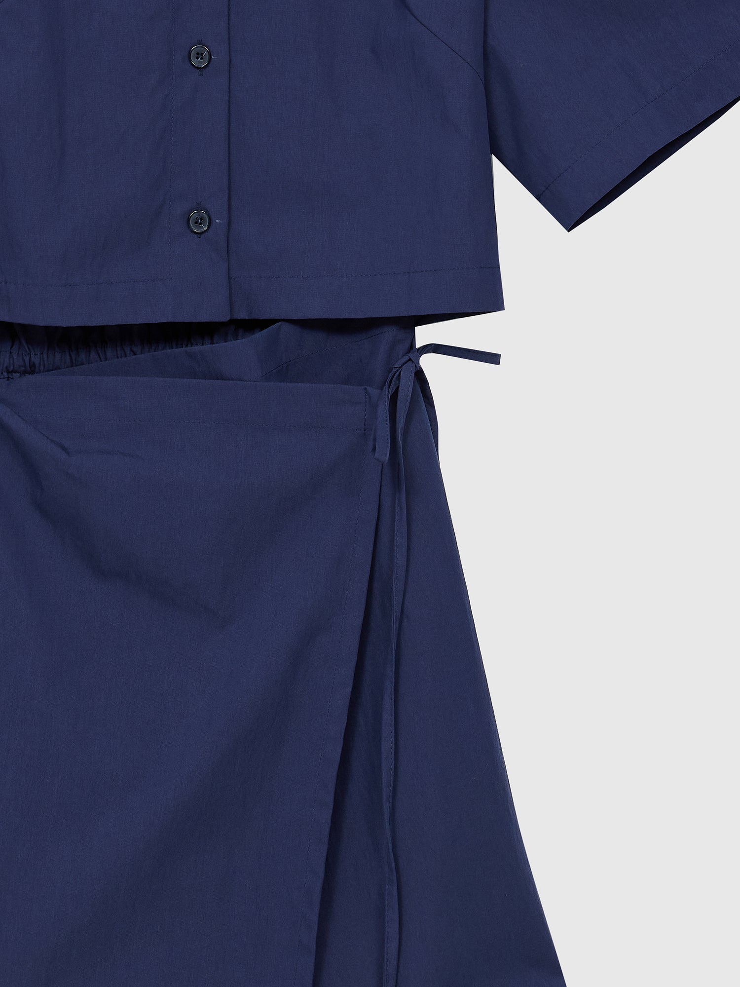 A closer look at the side view of our shirt dress, showcasing the intricate wrapping tie detail at the dress bottom.