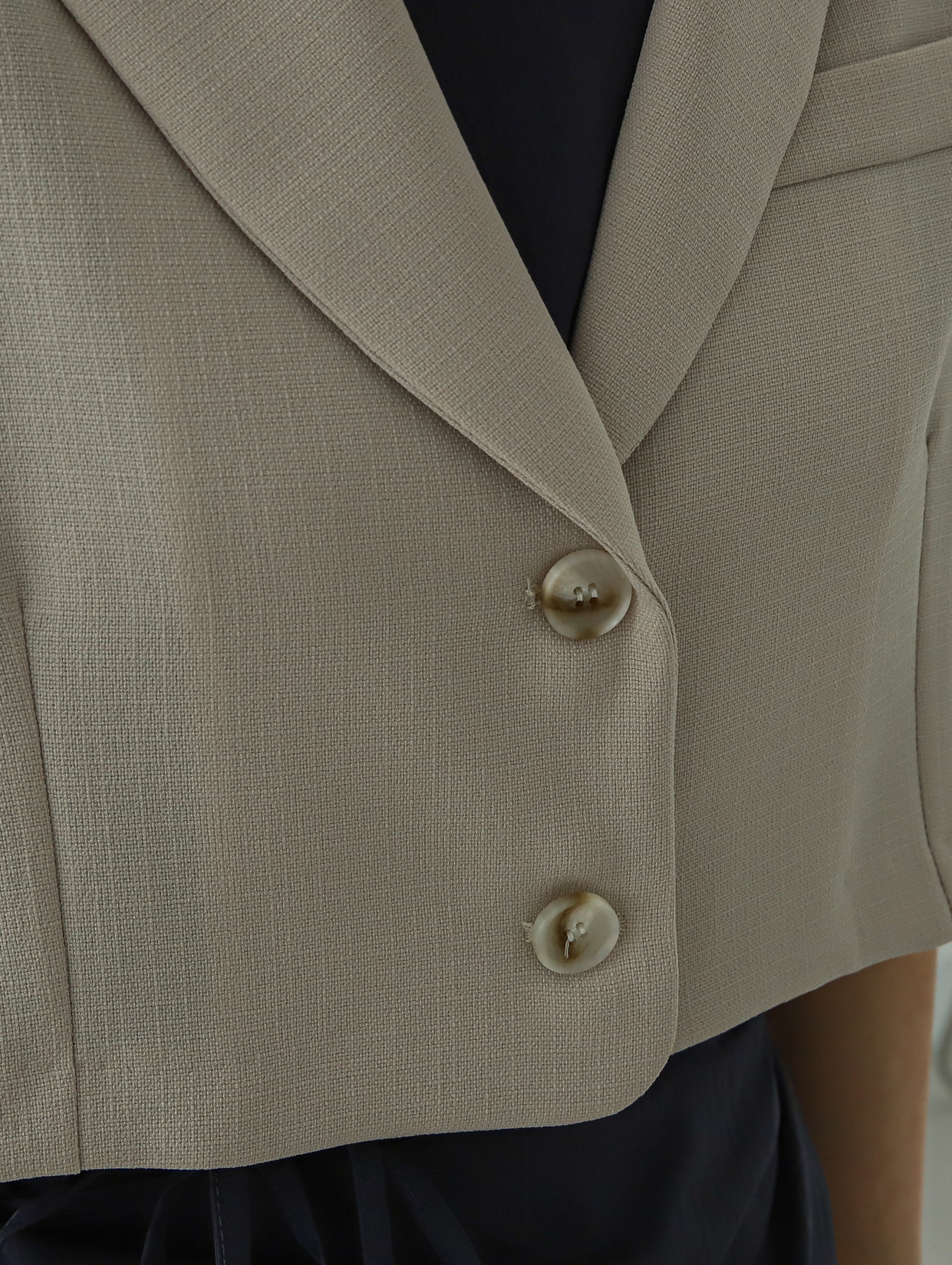 Zoomed-in shot of the blazer highlighting the button details.