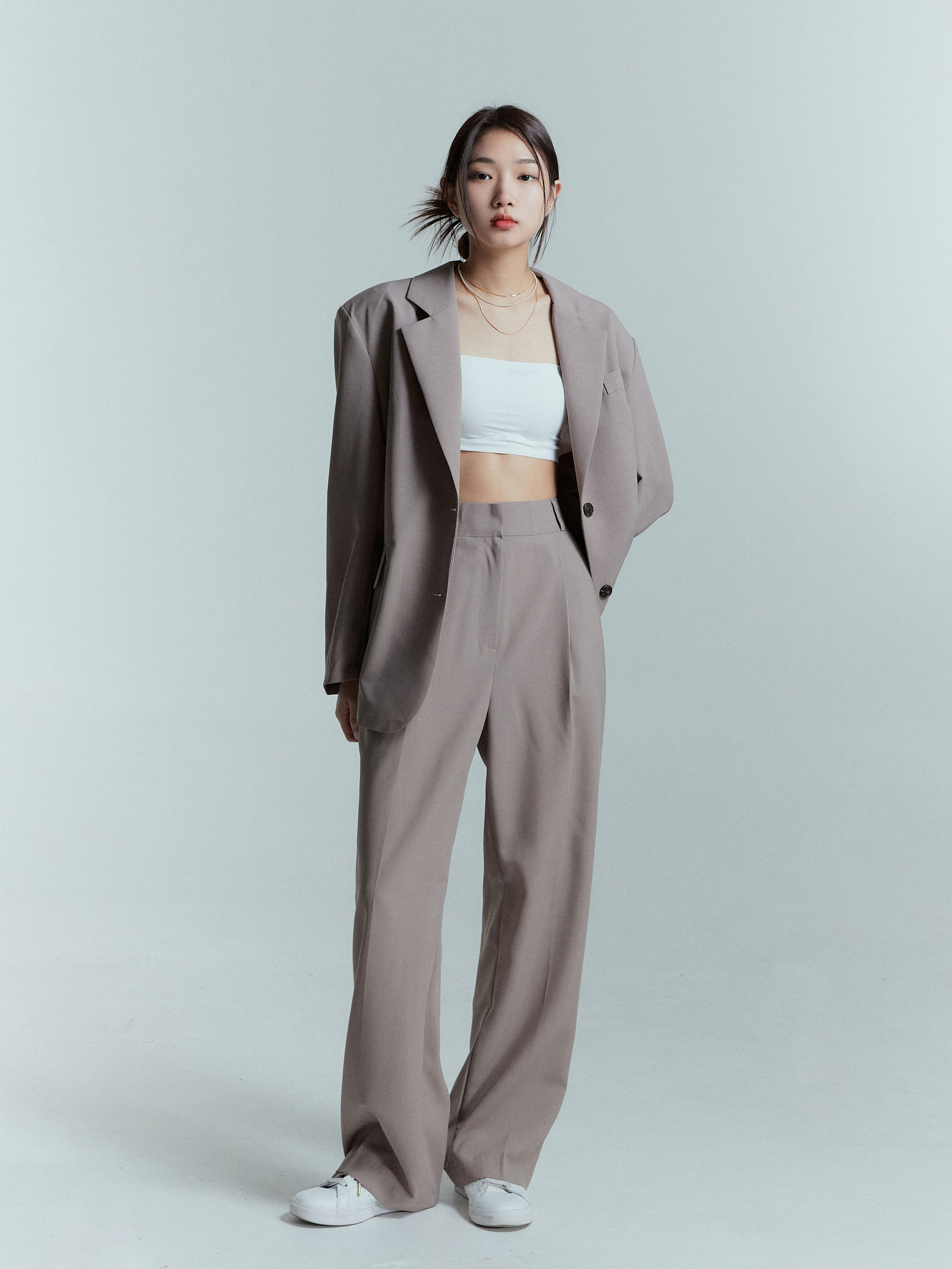 Full-shot of the model in Korean street fashion, confidently wearing the shoulder padded blazer, showcasing the full length fitting of the blazer.