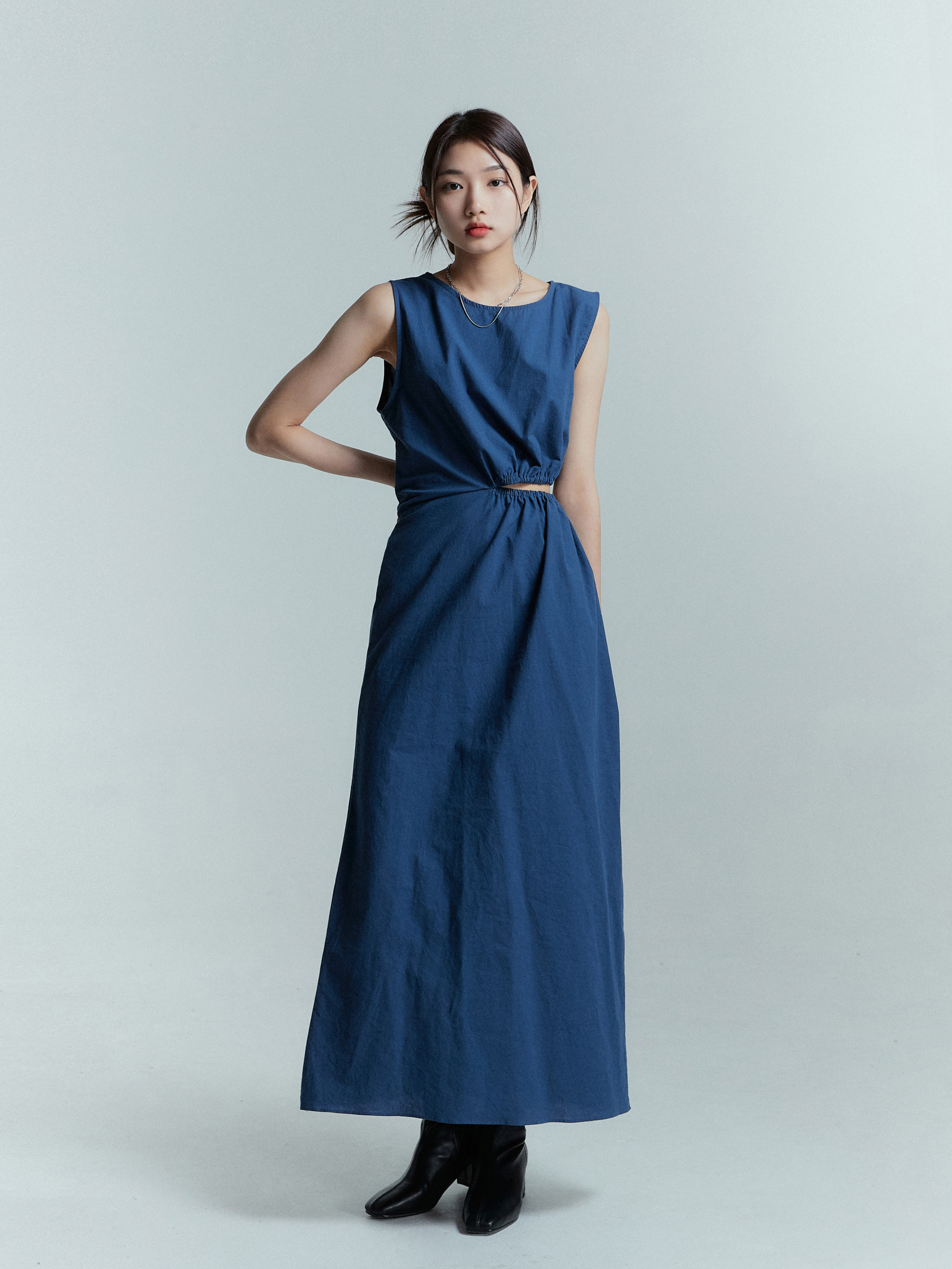 A model standing straight wearing the side-cut blue midi dress posed elegantly.