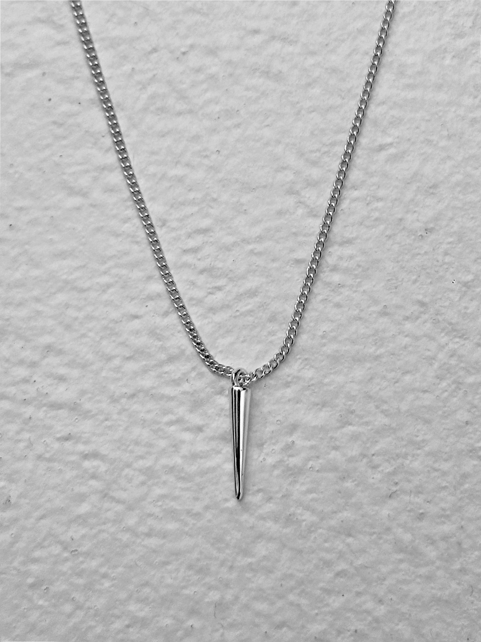 A close-up view of the silver spike pendant necklace highlighting the spike pendant detail.