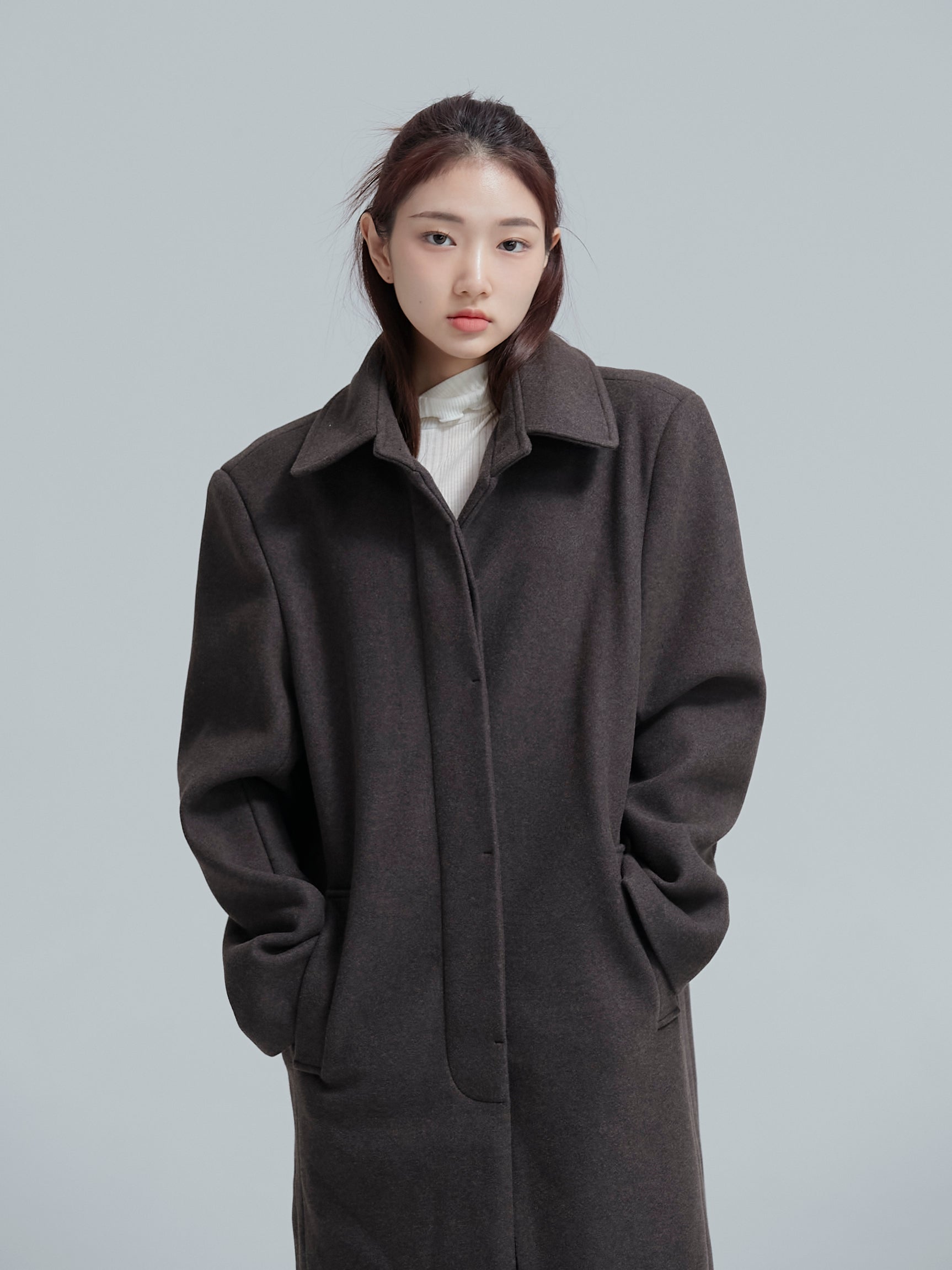 A zoomed-in shot of the brown single breasted overcoat showing its korean aesthetic outfits.