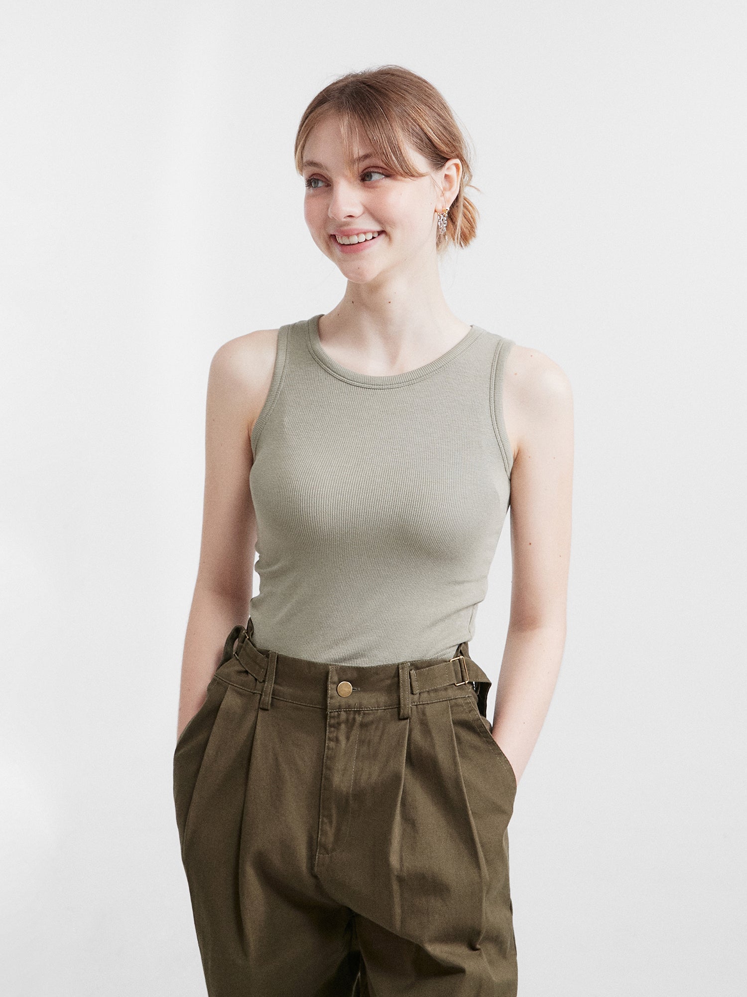 Model glancing on the side wearing the sleeveless tank top with her hands tucked inside the cargo pants.