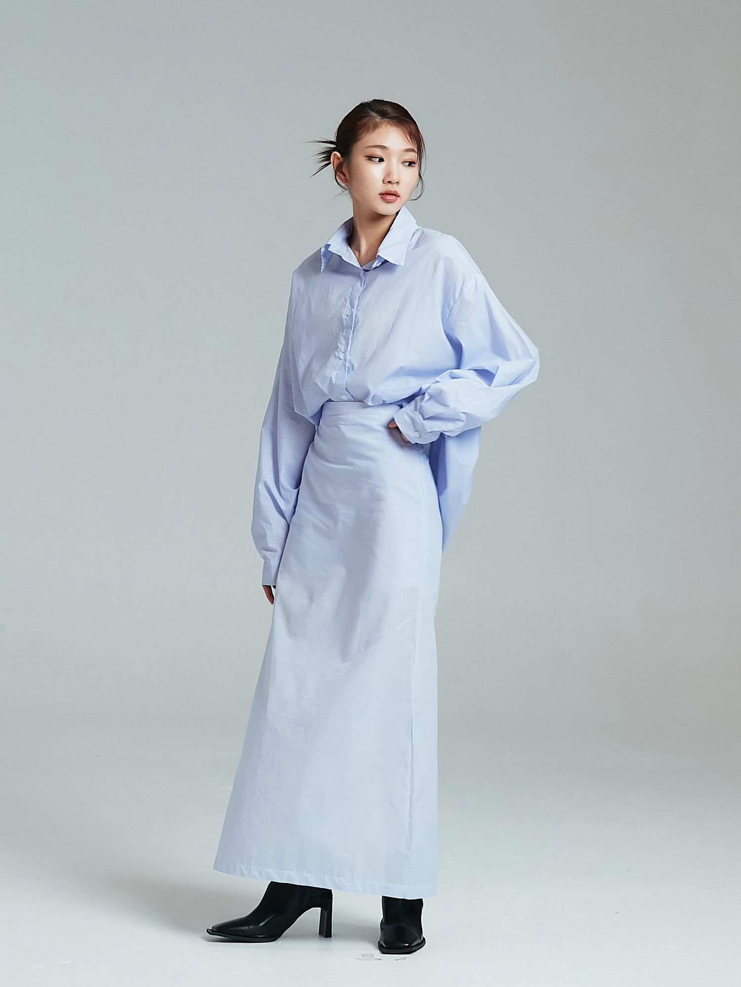 A tilted angle of the model wearing the slit maxi skirt showcasing its korean street fashion vibe.