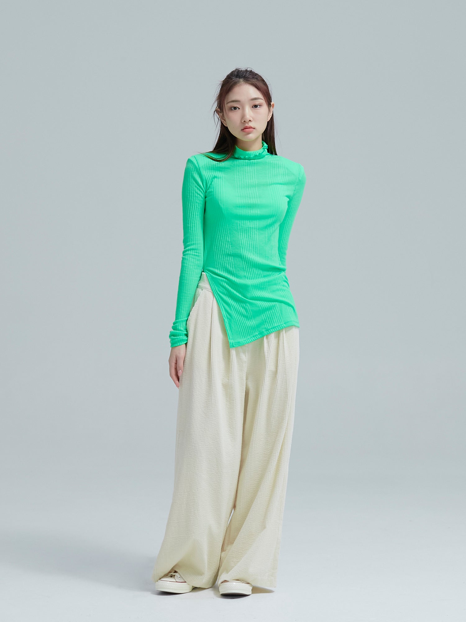 Full shot of the model wearing the neon green slit ribbed neck to show its full fitting of the top.