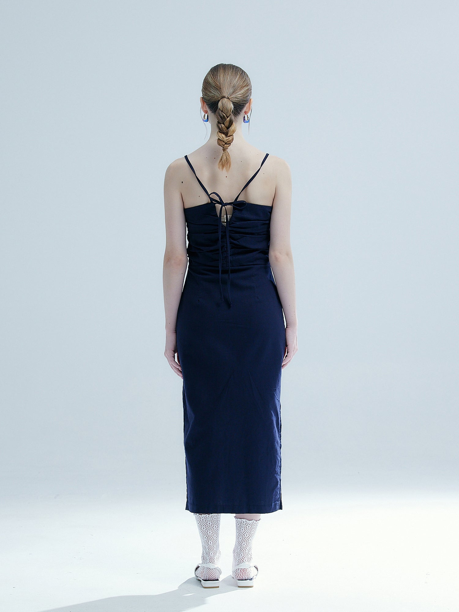 Back shot of the model wearing the navy smocked elastic dress showing the back design of the dress.