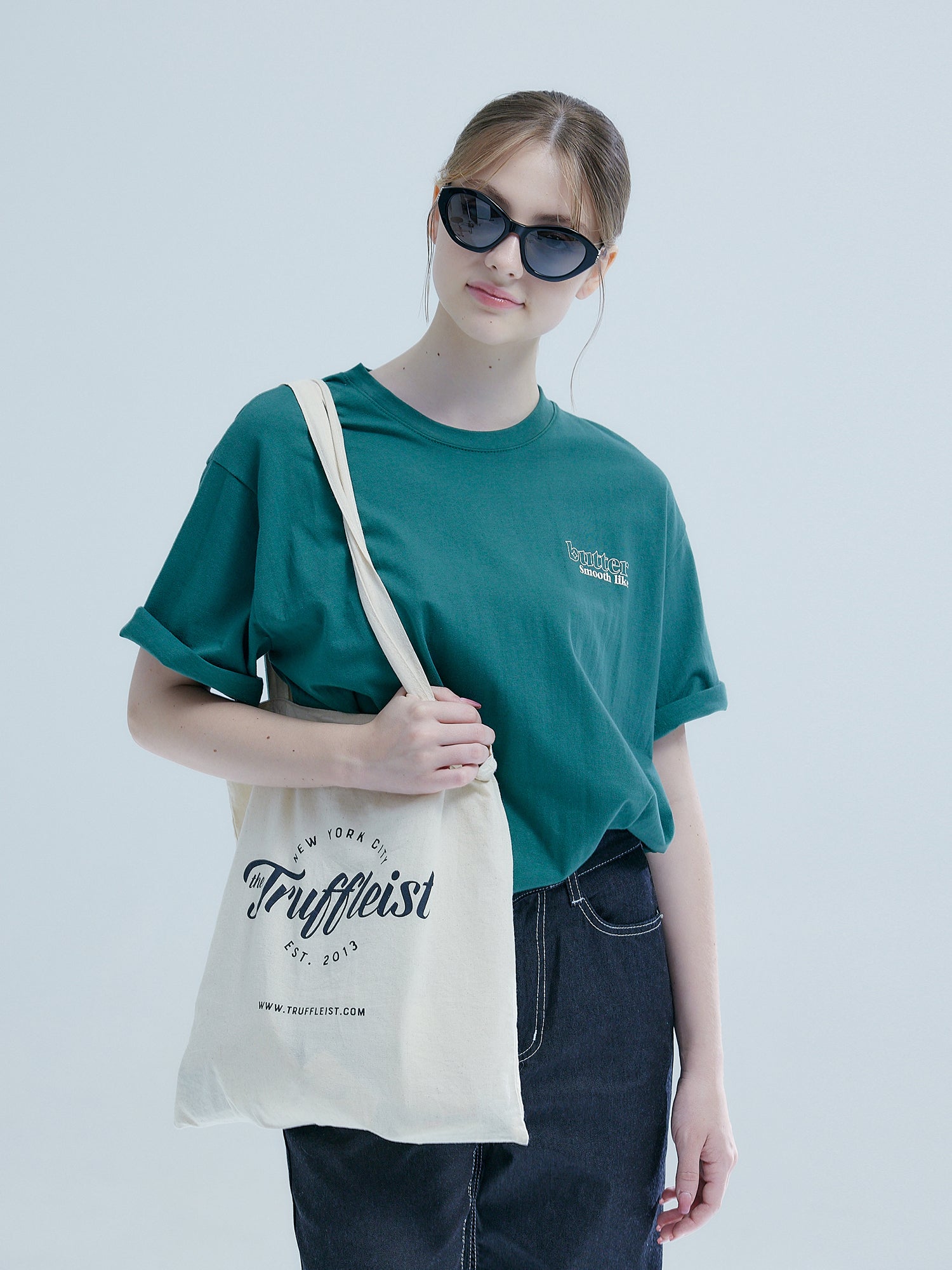 Exuding Korean street fashion, from a front perspective, the model effortlessly pairs her Japanese indigo 'Smooth Like Butter' t-shirt with a matching handbag.