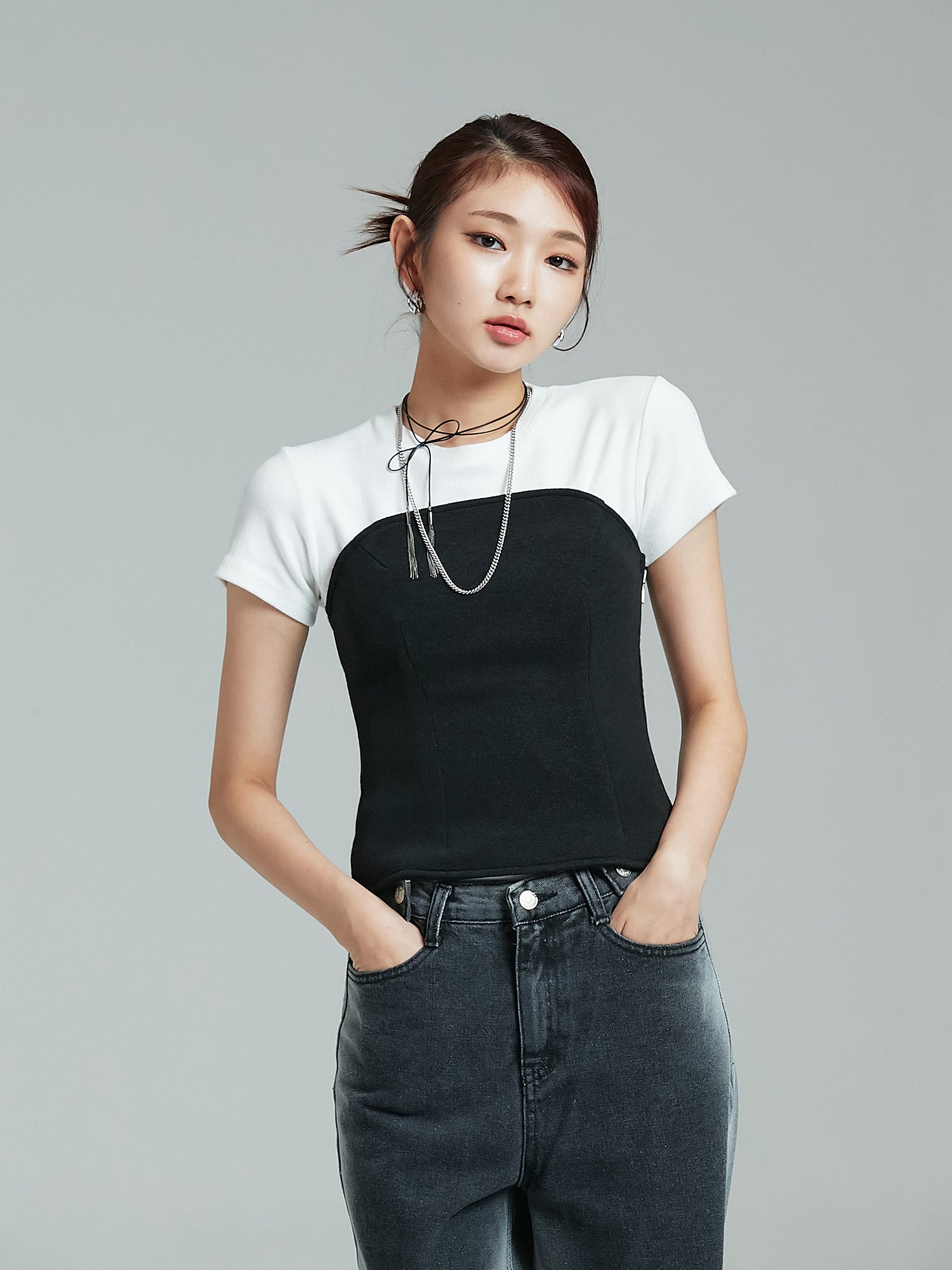 Front view of the model wearing the strapless top with her hands tucked inside the pants showcasing the korean street fashion vibe.