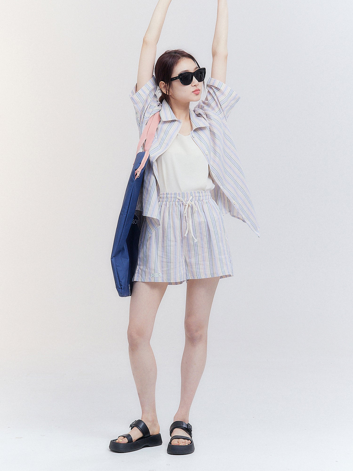 Full-shot of the model wearing the stripe print shirt with stripe print shorts with the sets.