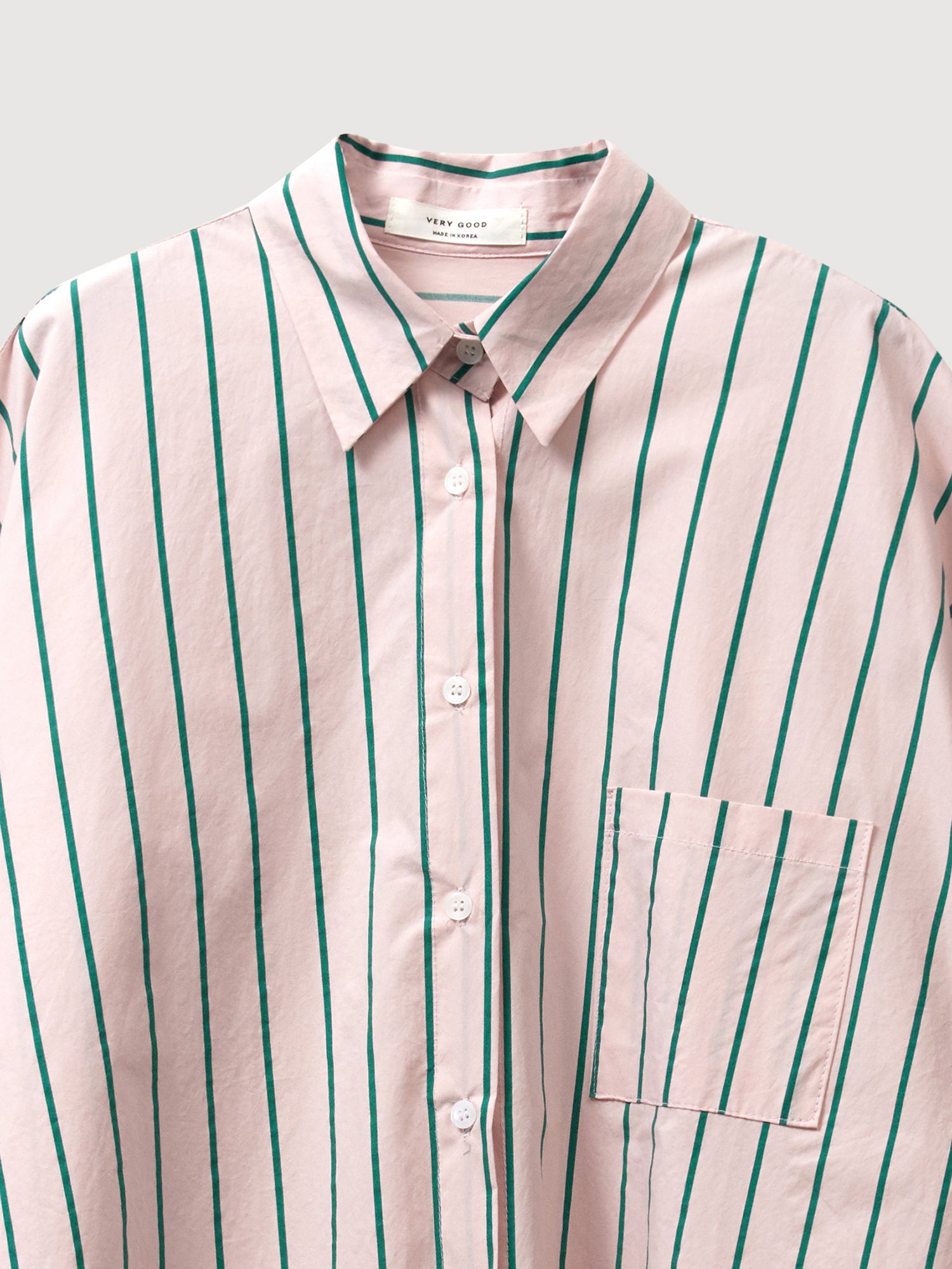 A detailed view of the striped loose shirt, showcasing the intricate fabric detail and pointed collars at the front in exquisite detail.