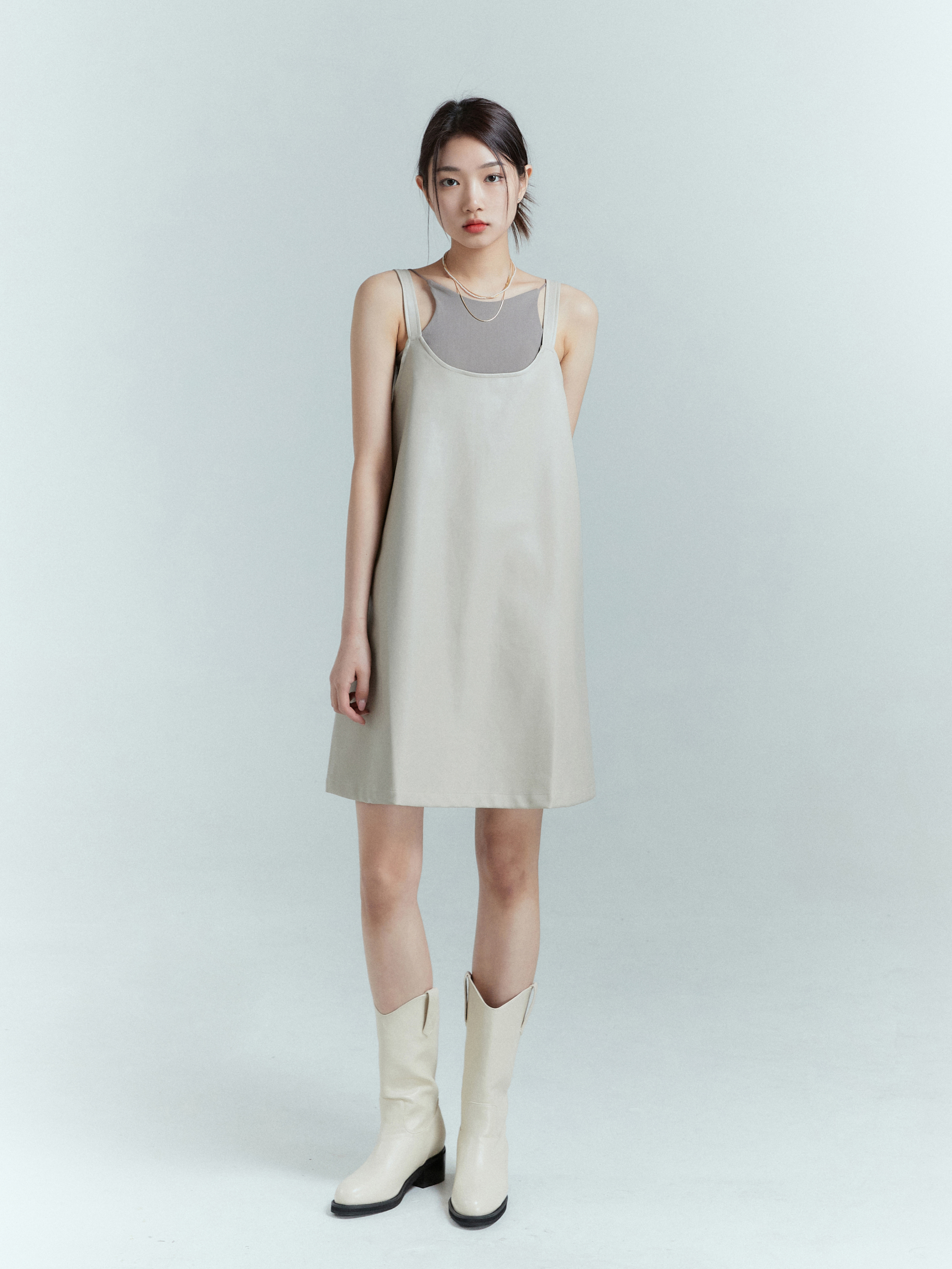 In a poised standing pose, the model showcases the tank dress, gracefully displaying its full-length with confidence.