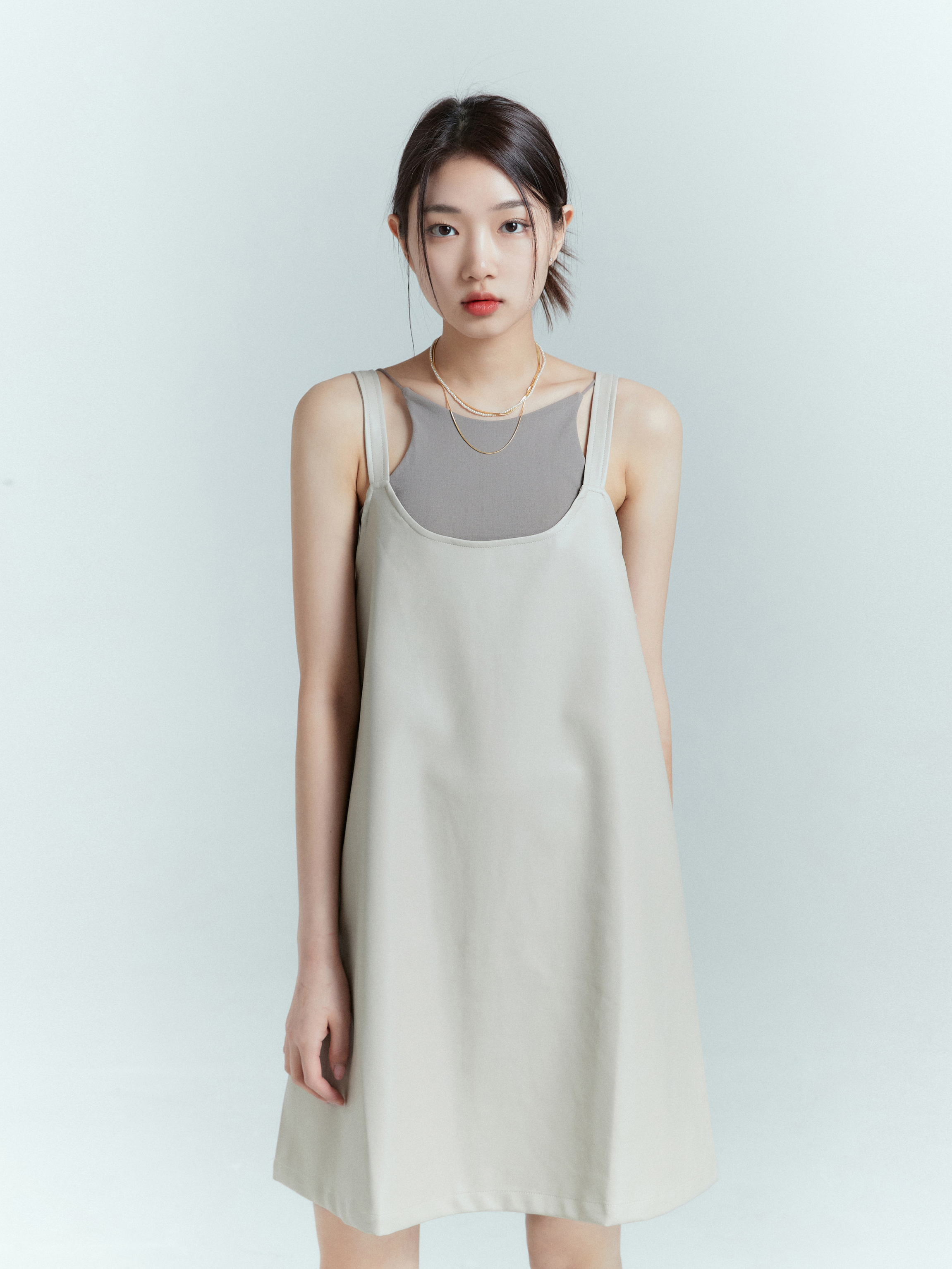 A model wearing a tank dress paired perfectly with a matching spaghetti strap tank, captured in a medium shot.