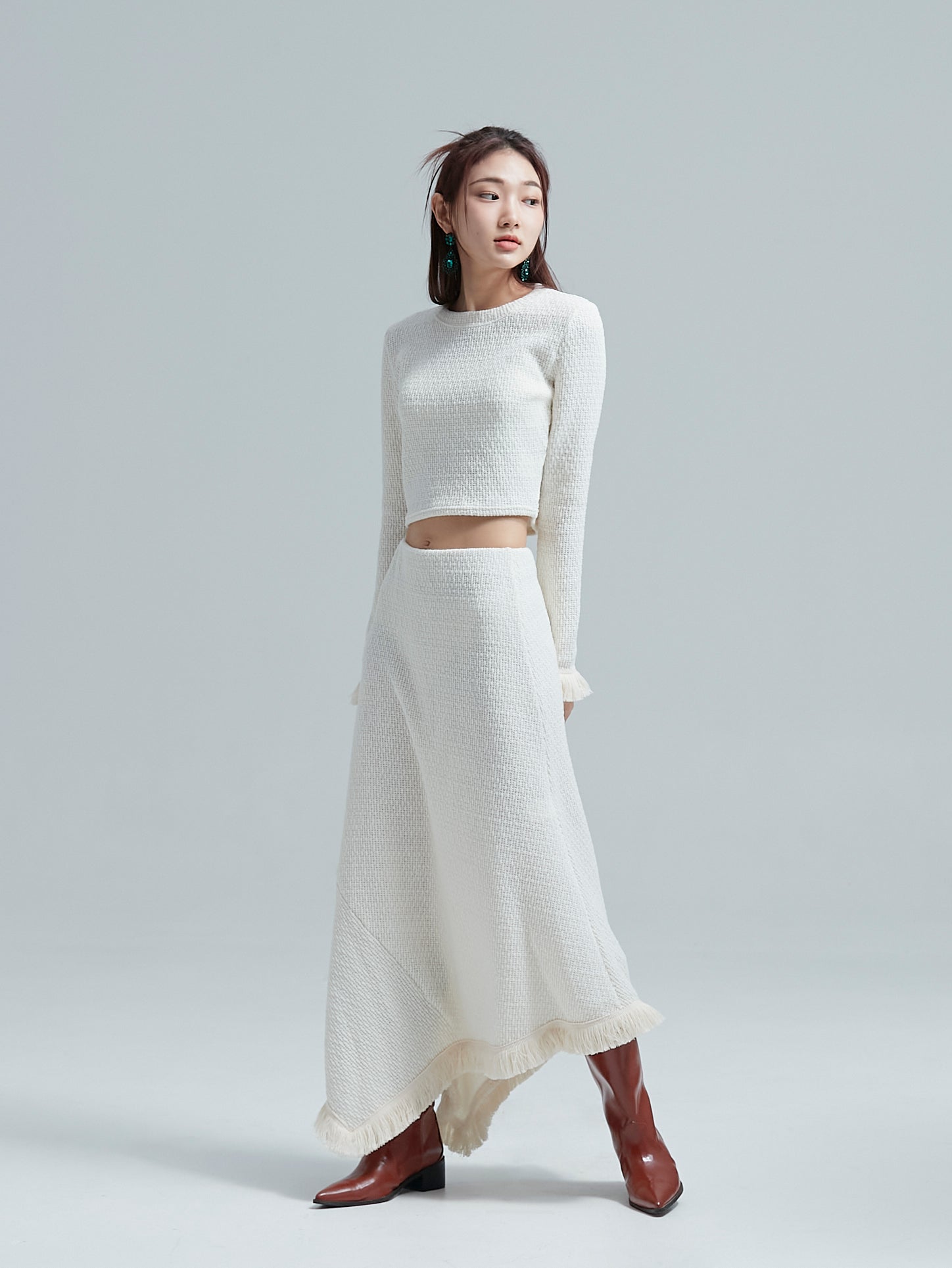 A tilted angle of the model showcasing its tassle top and skirt set to accentuate its korean aesthetic outfits.