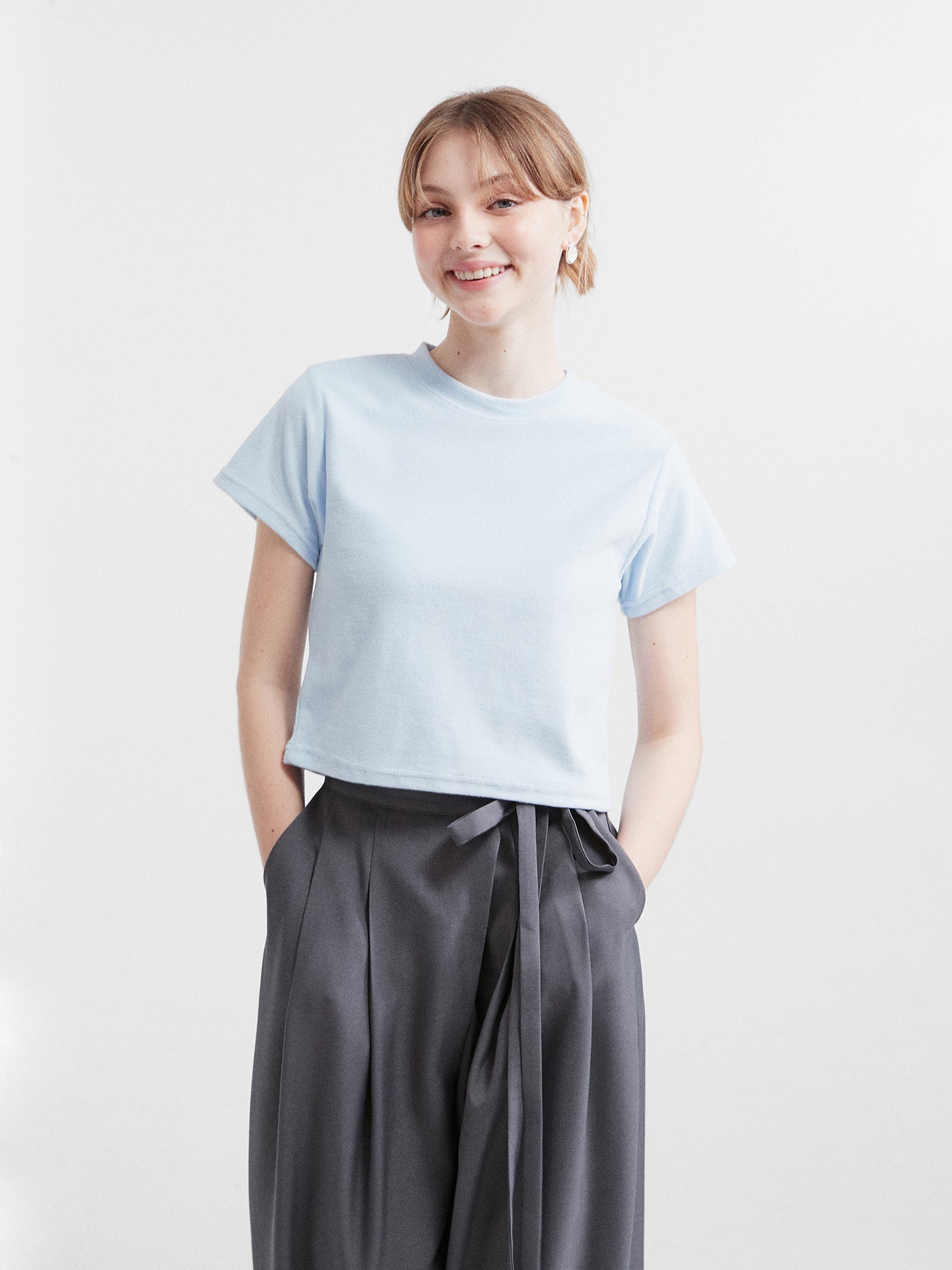 A model is facing front wearing the light blue crewneck top.