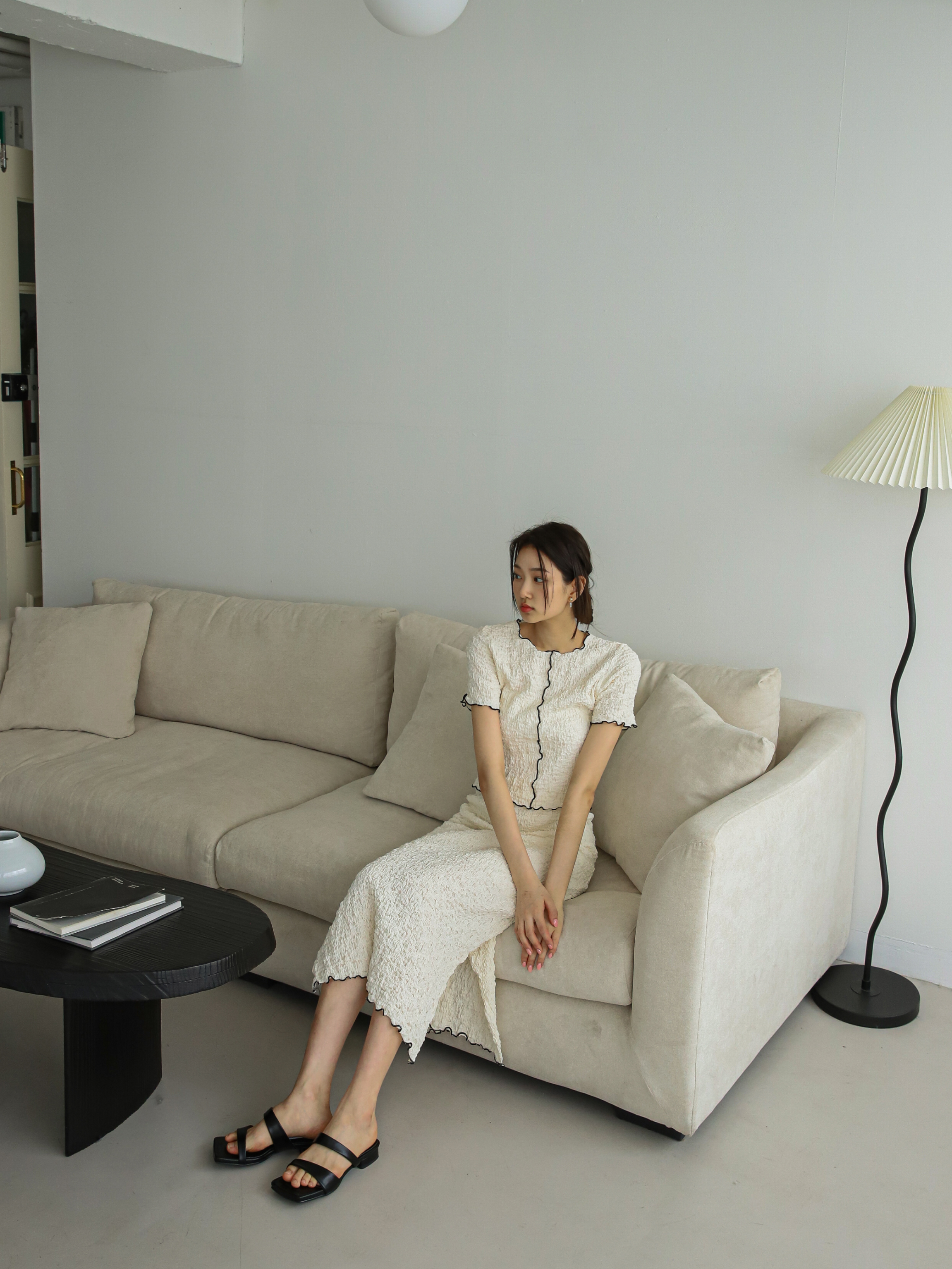 A model in a seated position wearing the textured top matched with the textured bottom.