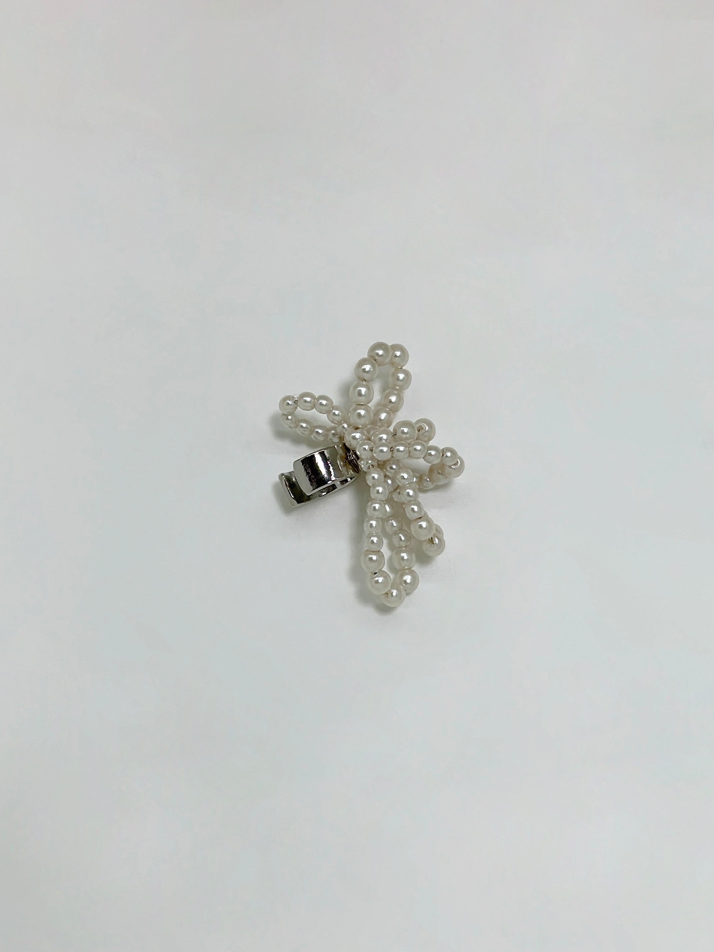 Product detailed view of the the silver bow ear cuff that showcase its earring designs.