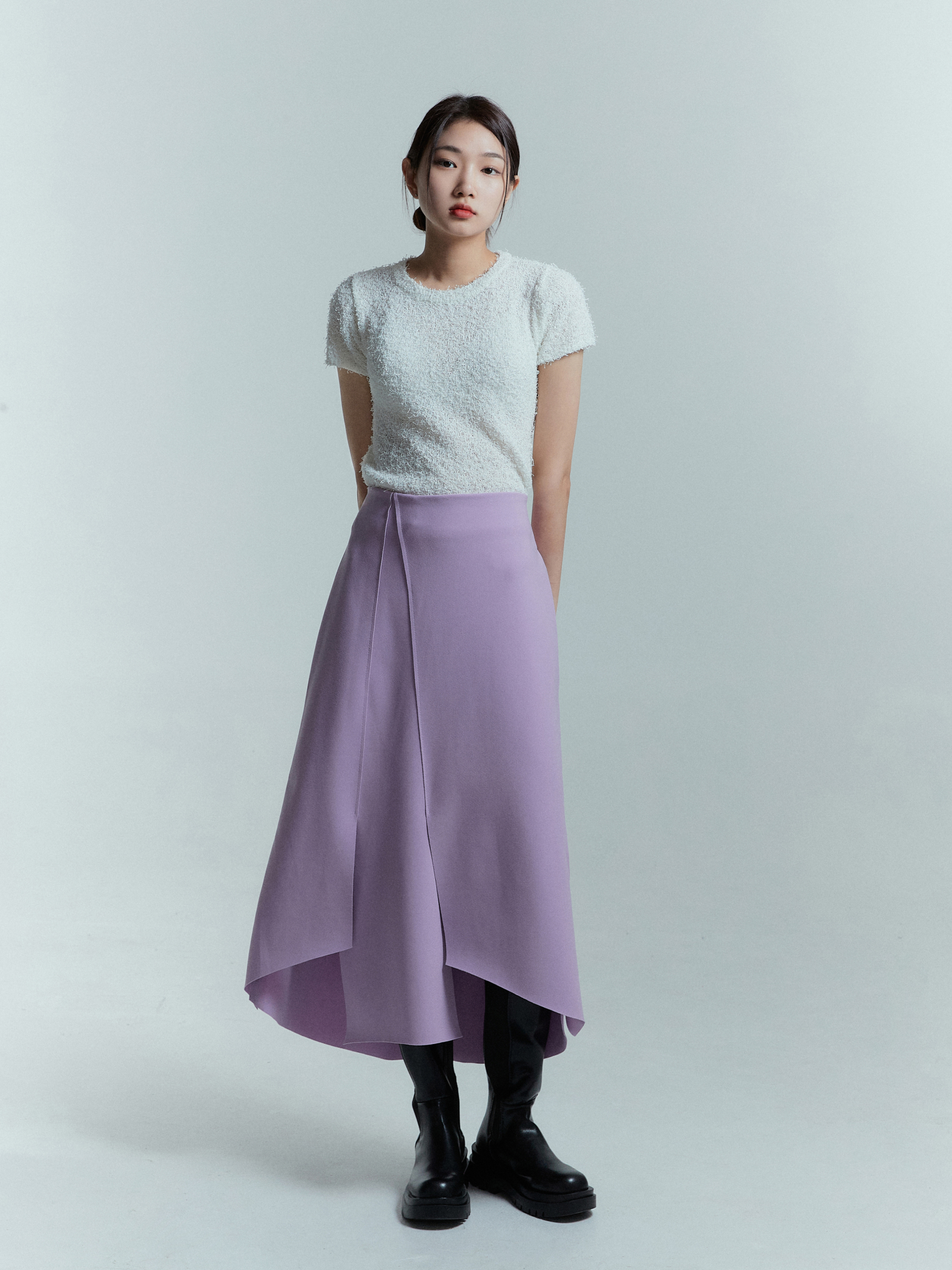 A model standing wearing the lavender tulip wrap skirt.