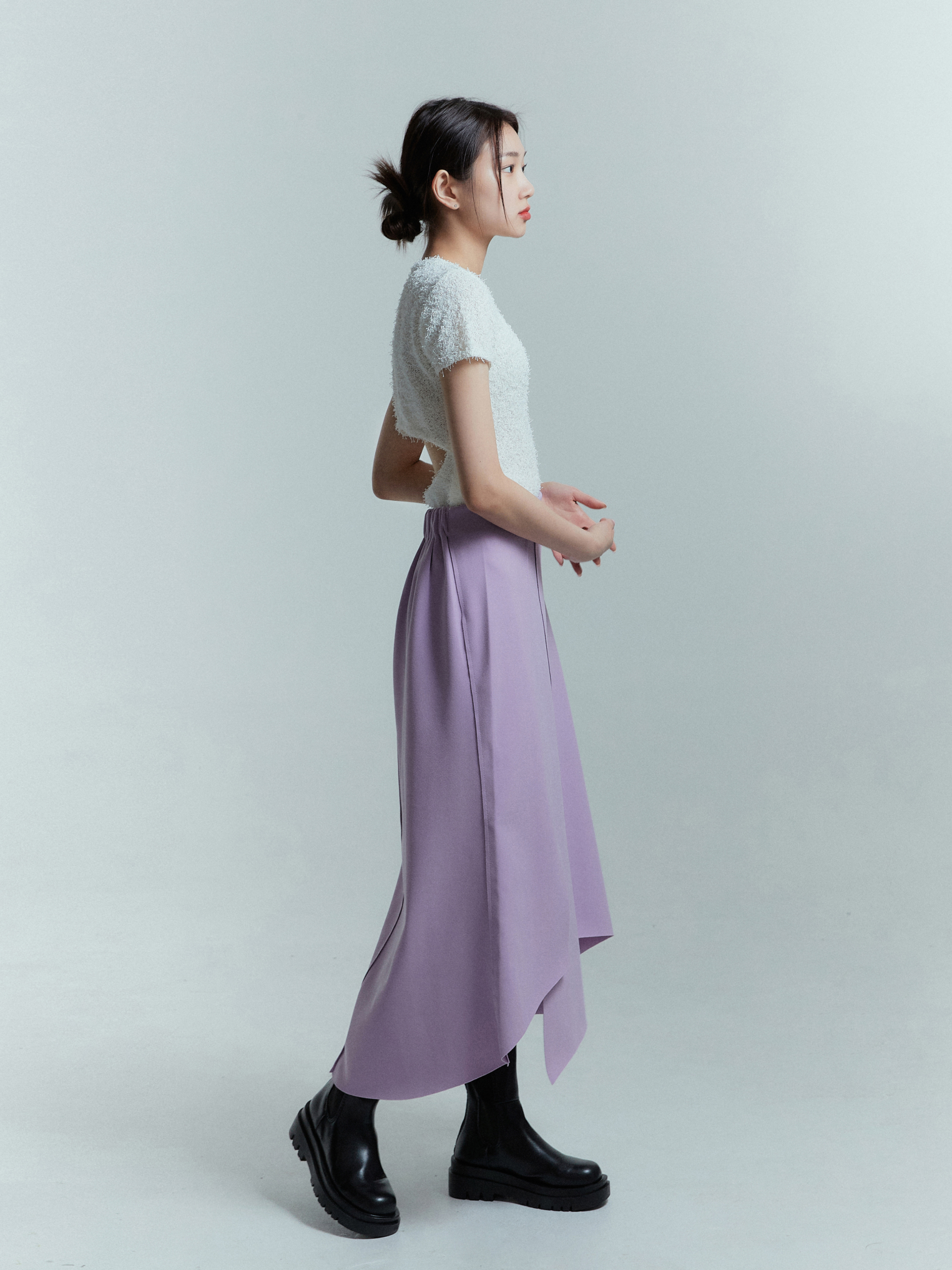 A side view captures the model wearing the lavender tulip wrap skirt, beautifully showcasing its flattering silhouette and unique side angle.