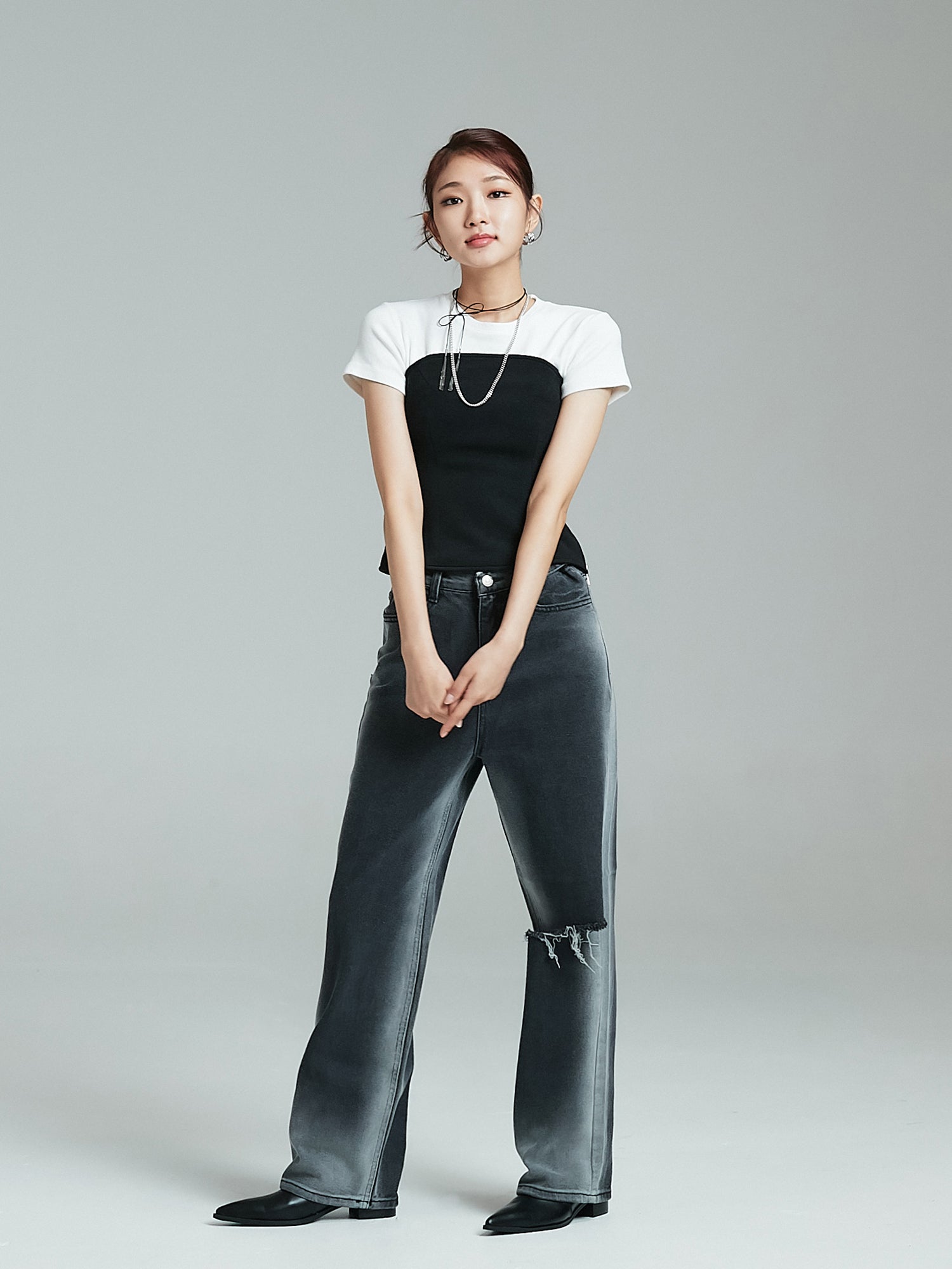 Front shot of the model posing while wearing the washed rip jeans to showcase its korean street fashion.