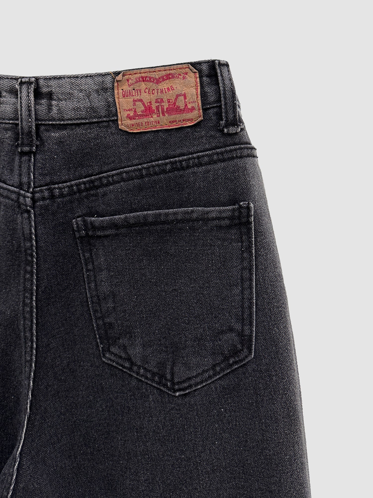 A close-up perspective highlighting the intricately designed back details of the washed ripped jeans, with a particular focus on the pocketed region.