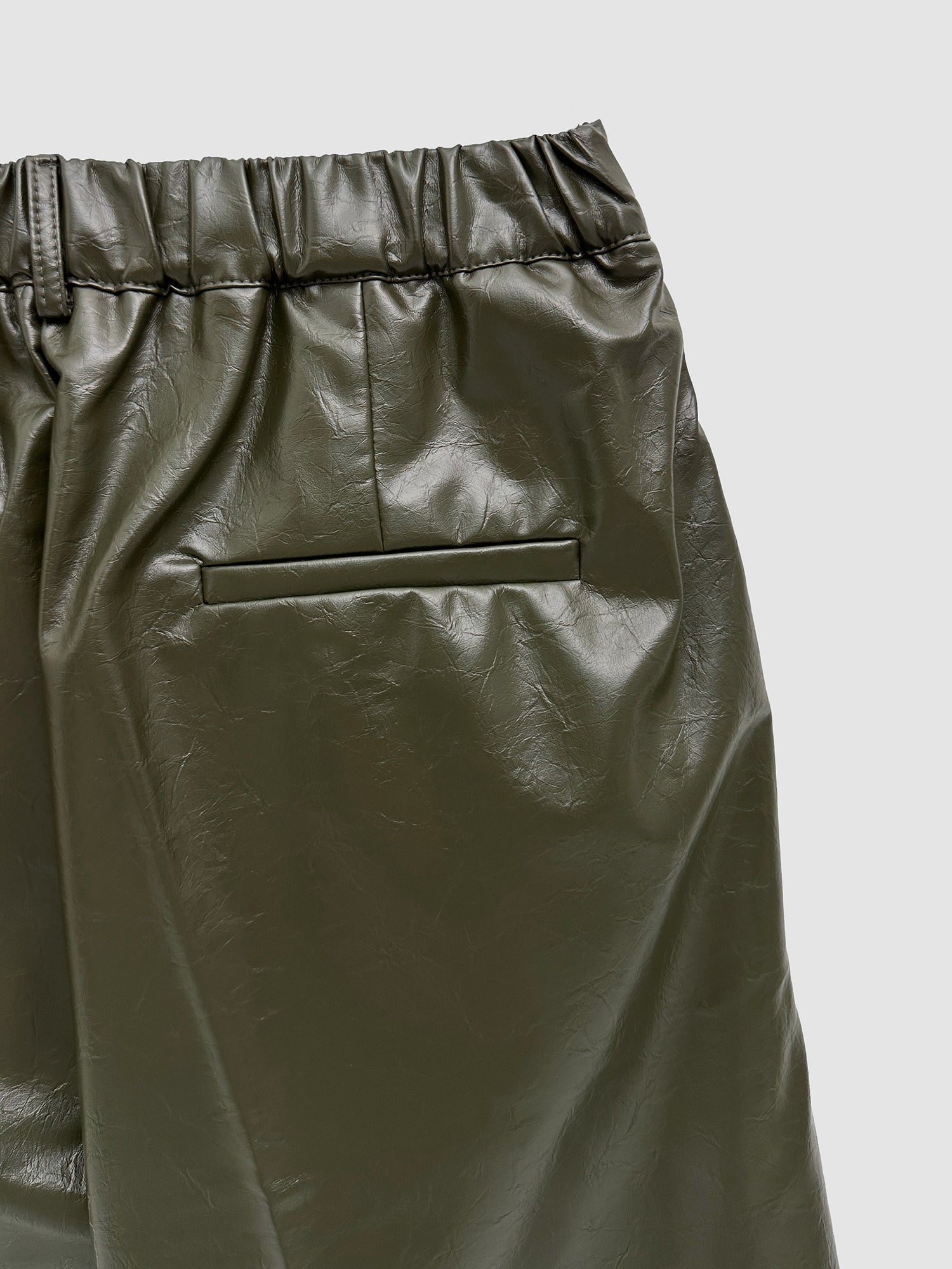 A zoomed-in shot of the wide leather shorts showing the elasticated waistband detail and the texture of the fabric.