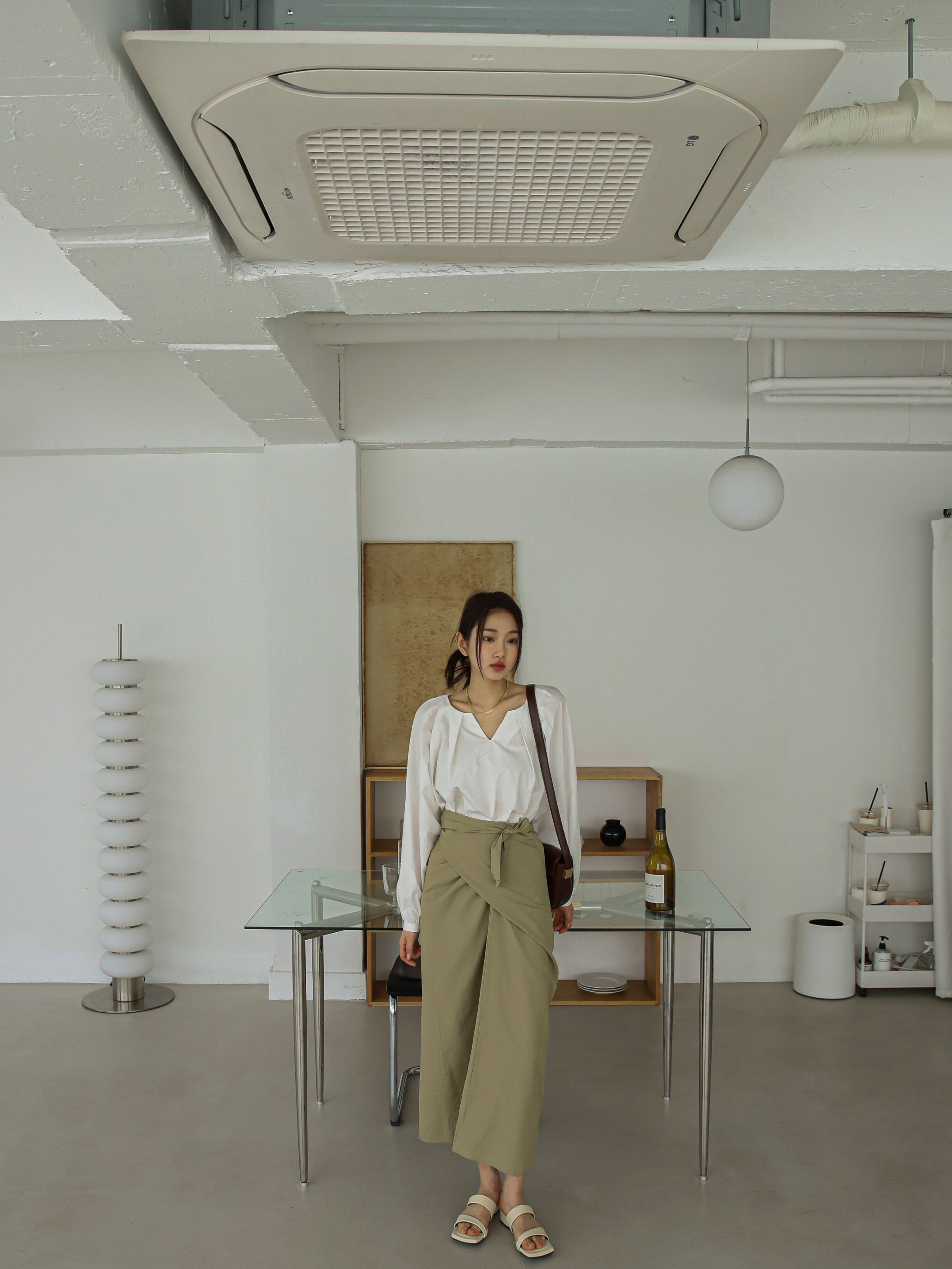 A long shot of a model wearing the wrap belted midi skirt.