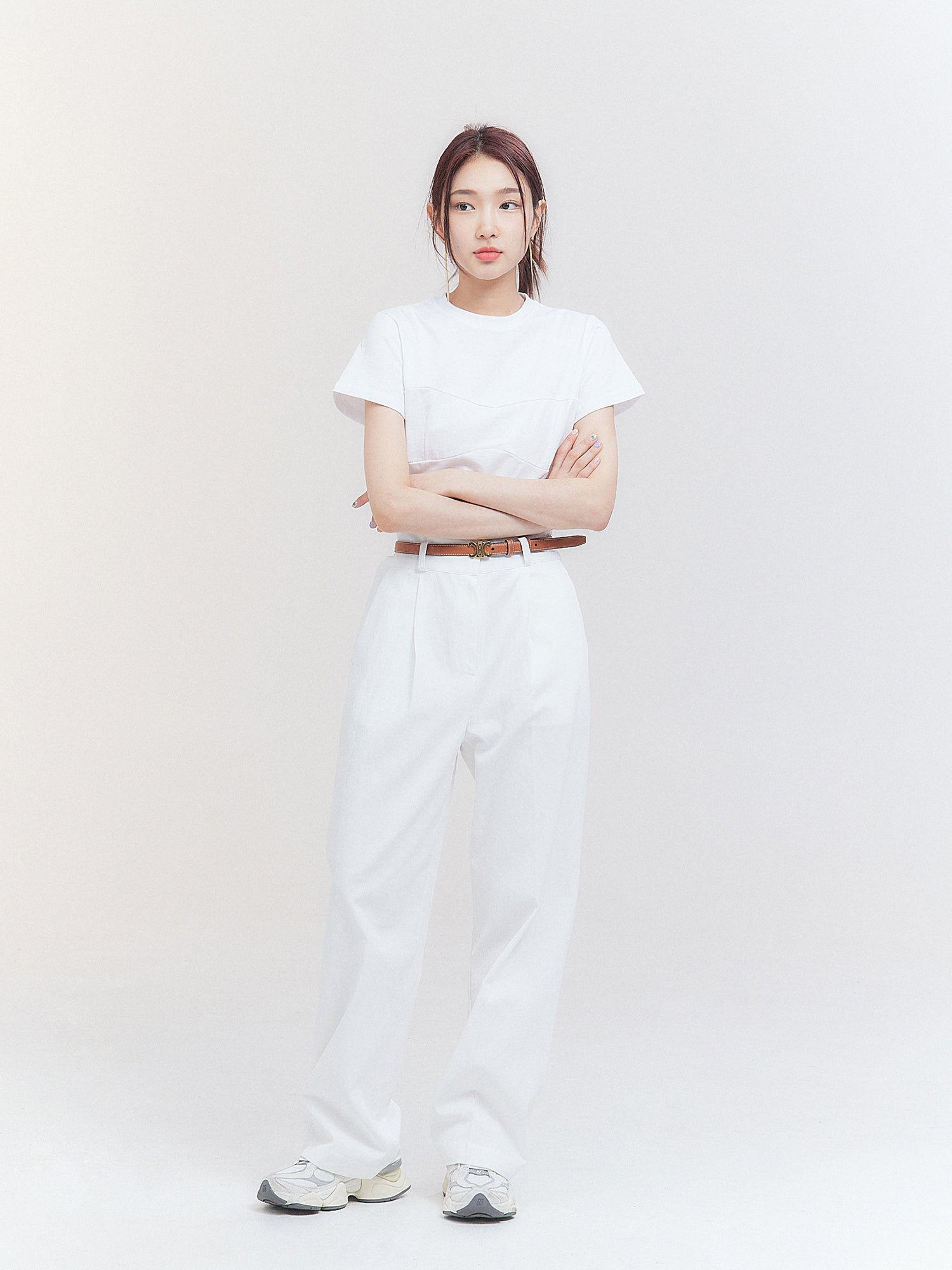 The image captures a stunning model wearing a white belted pleated trouser, perfectly exemplifying the essence of Korean aesthetic fashion.