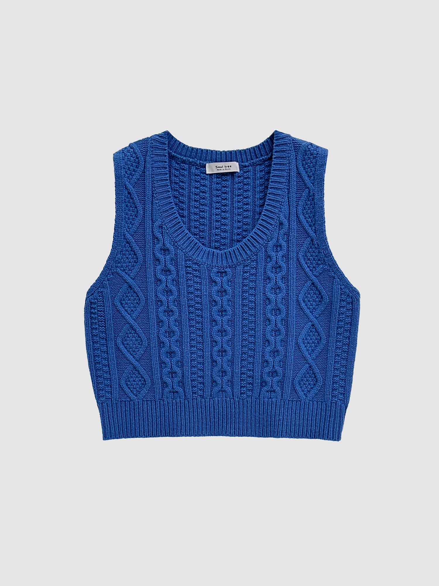 Product detailed shot of the blue cable knit vest showing its front detailed designs of the top.