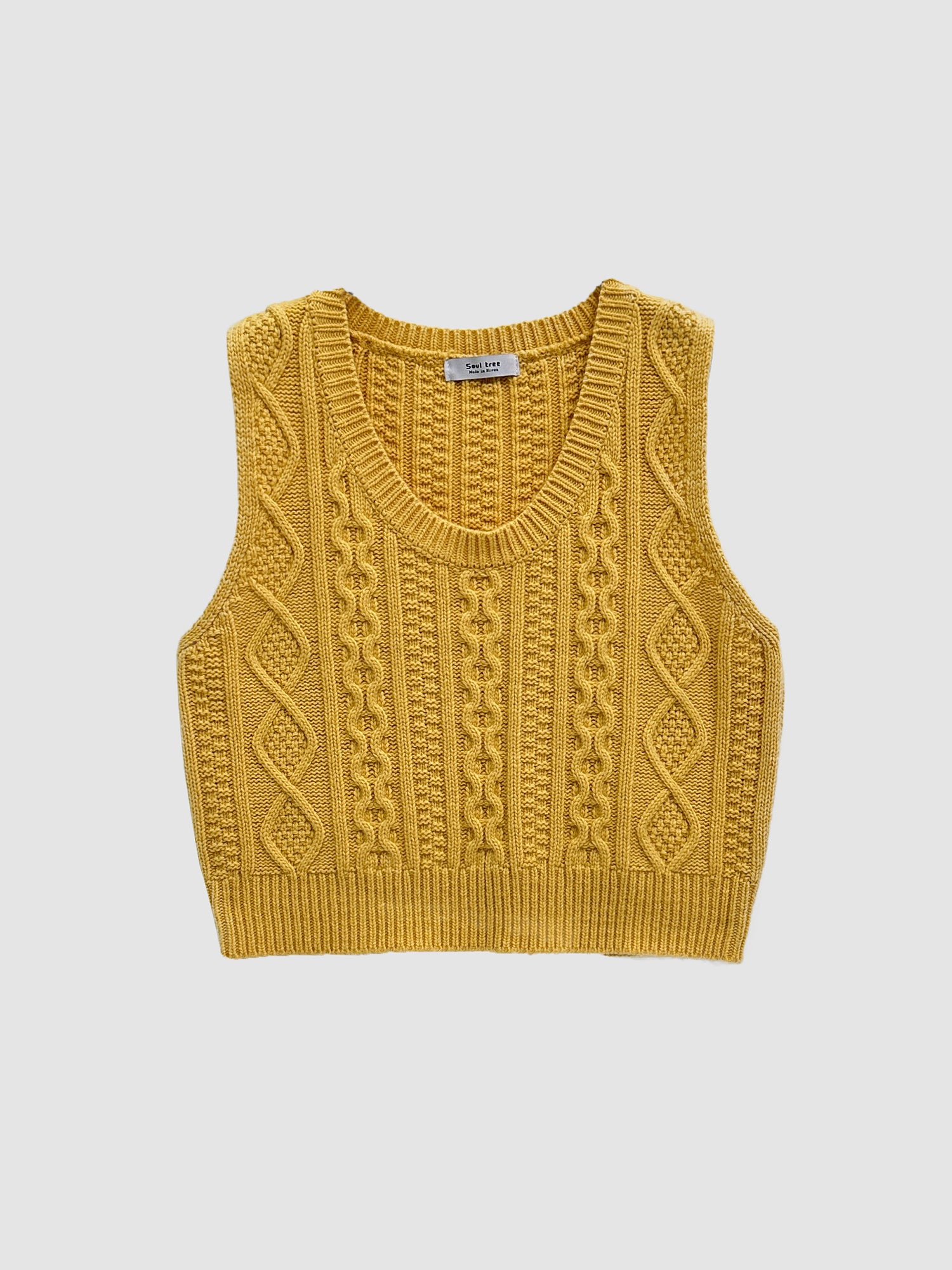 Product detailed shot of the yellow cable knit vest with white backdrop.