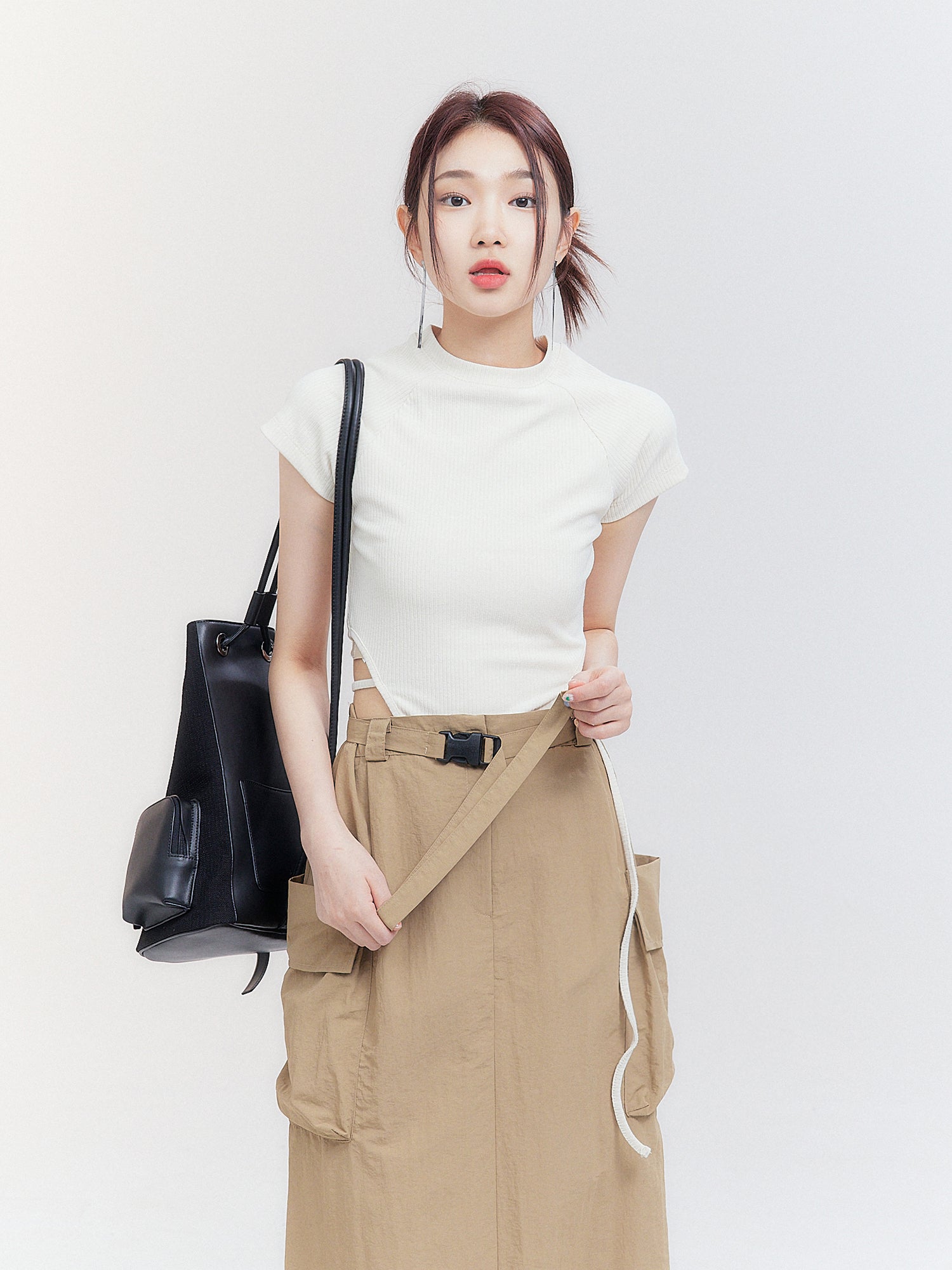 Capture a close-up view of the model flaunting the cargo midi skirt, emphasizing the intricate belt details that exude Korean street fashion flair.