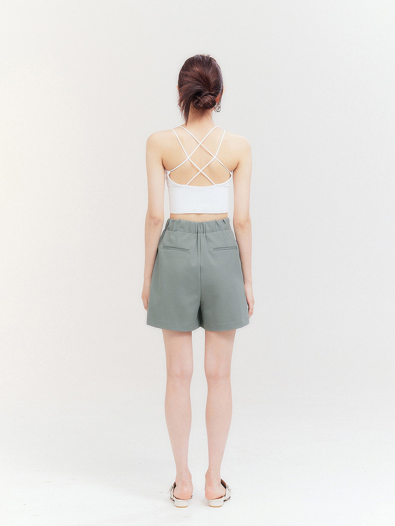 Back view of the model wearing the white crisscross top showing the back design of the top.