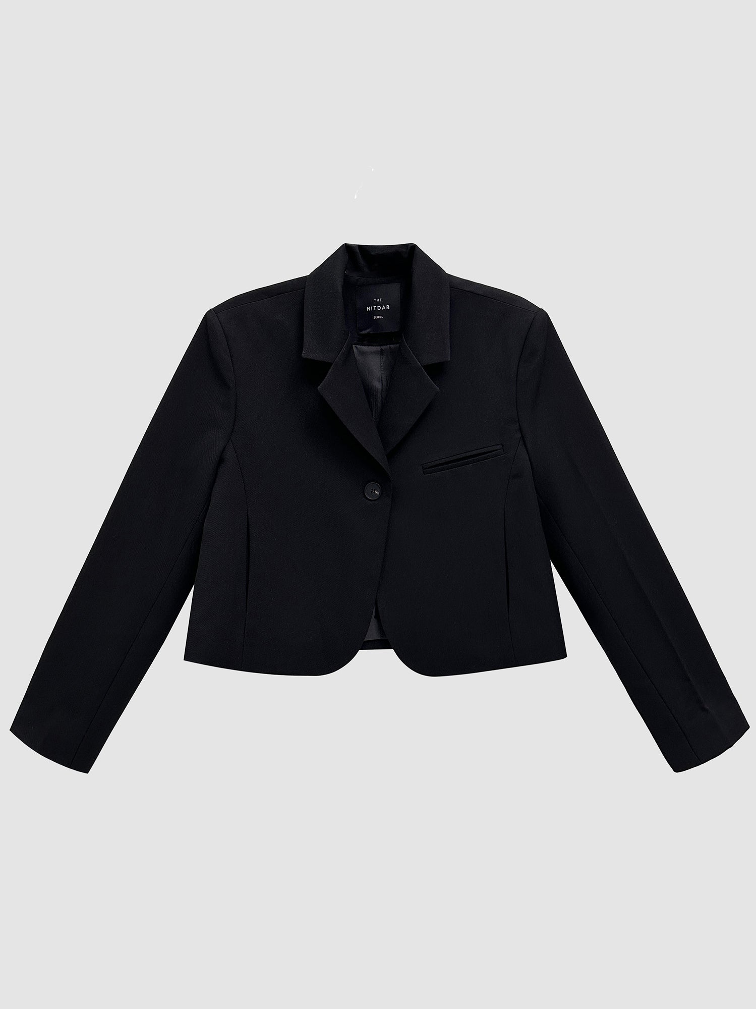 Product detailed view of the black cropped blazer with gray backdrop.