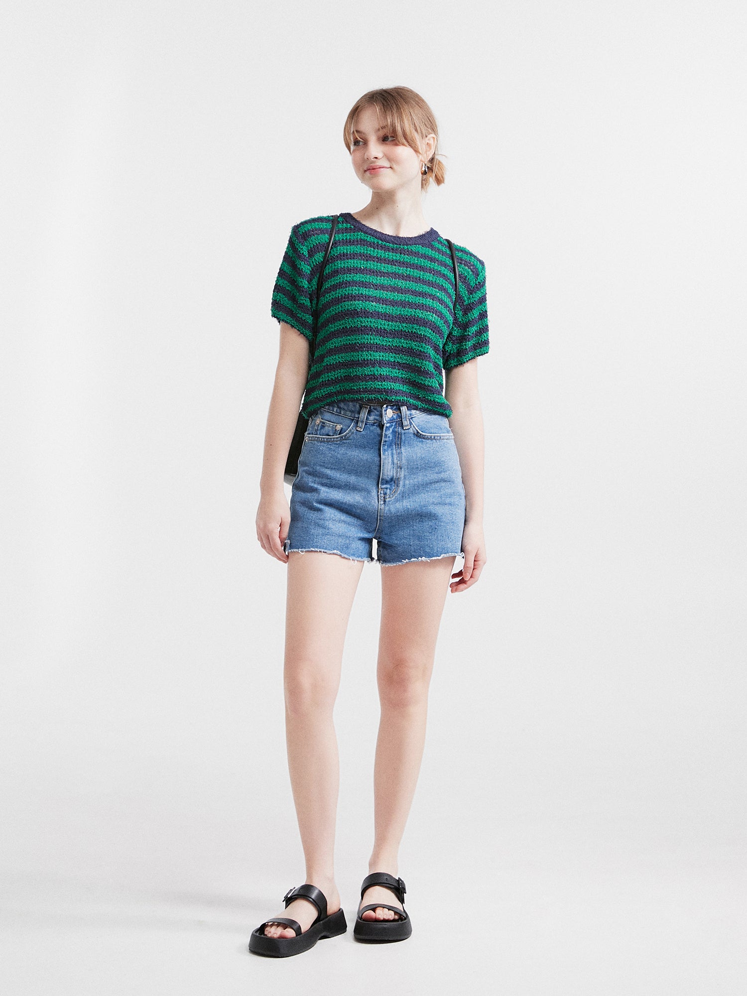 A full-length view of the model wearing the jean shorts, showcasing the perfect fit and style of this wardrobe essential.